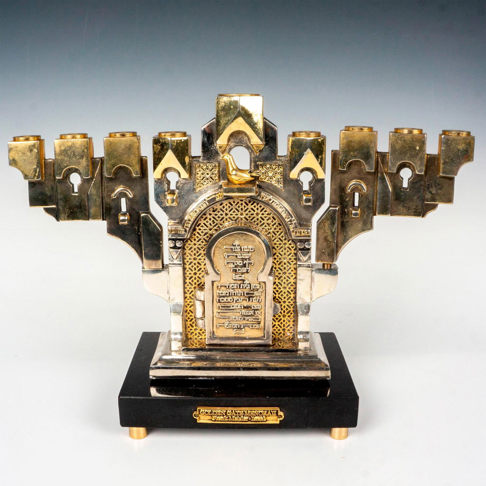 Frank Meisler (Israel, 1929-2018) Golden Gate Menorah + Base: Features a Menorah in silver and gilded tones made to look as a structure, above an Oriental dome with Hebrew scripture. Fitted with two swiveling arms and a dove atop the dome. Signed along the side
