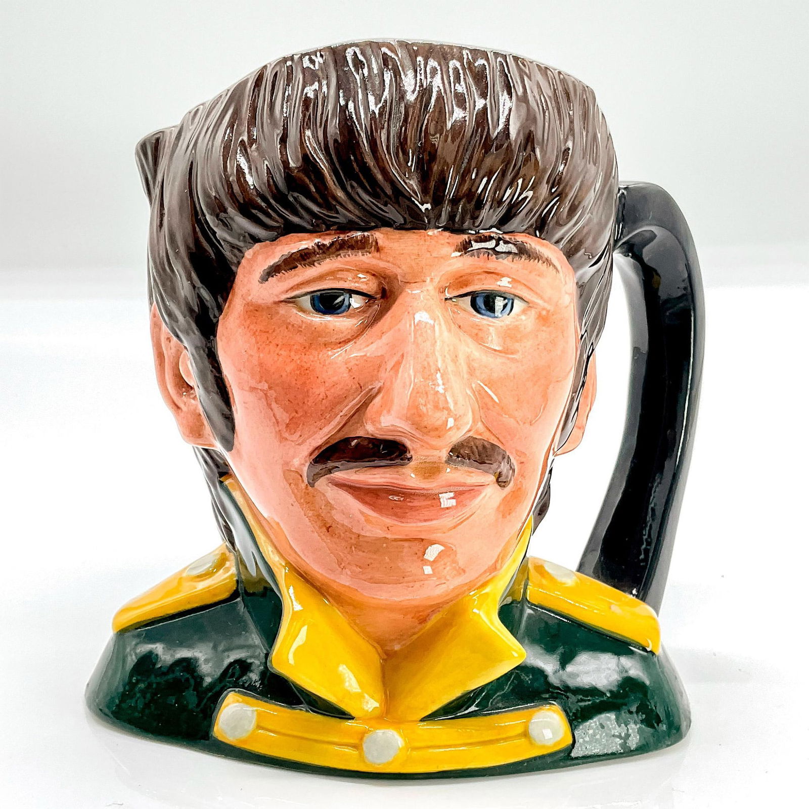Ringo Starr D6726 - Odd Size - Royal Doulton Character Jug: Black tunic; yellow collar and epaulettes. Richard Starkey (b.1940) was the drummer for the Beatles until they disbanded in 1970.Series: The Beatles. Royal Doulton backstamp. Artist: Stanley J. Taylor
