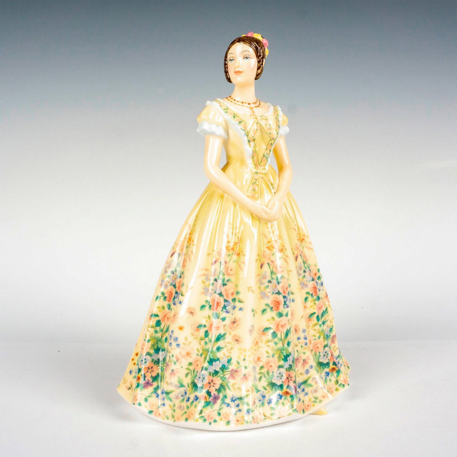 Queen Victoria - HN5705 From the Young Queens Collection - Royal Doulton Figurine: Limited edition, hand decorated bone china modeled as young Queen Victoria wearing a yellow floral gown. Royal Doulton backstamp. Artist: Neil Faulkner Issued: 2014 Dimensions: 9"H Edition Number: 126