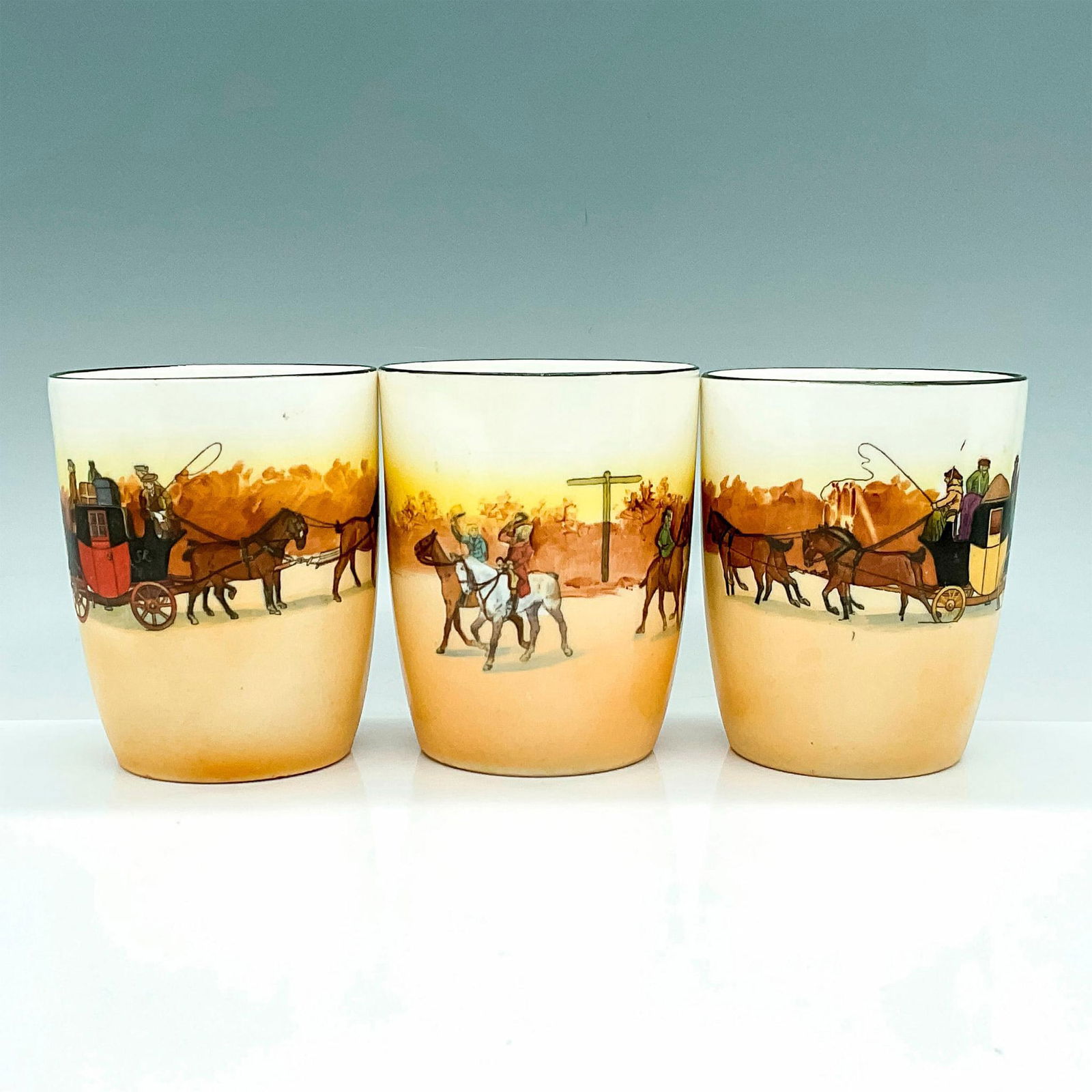 3pc Royal Doulton Seriesware Cups, Coaching Days: Three exquisite cups, each portraying distinct scenes of the English countryside, complete with horses and carriages. Royal Doulton backstamp. Issued: 20th Century Dimensions: 3.25"L x 2.5"W x 3.75"H