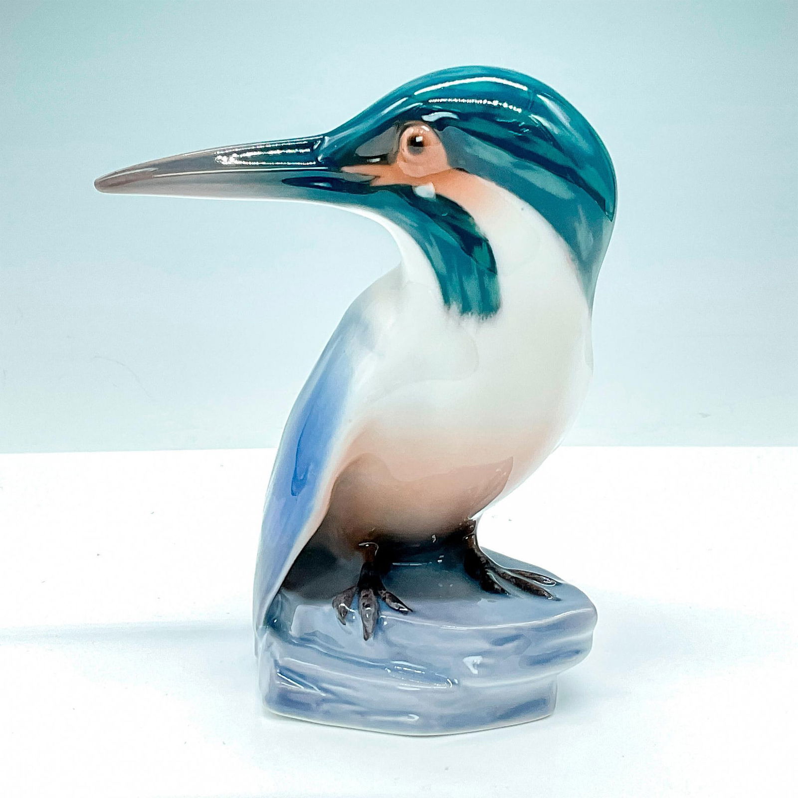Bing and Grondahl Porcelain Figurine, Kingfisher: Striking glossy figurine of a kingfisher with a vivid blue and green body and head, perched gracefully on a rock #1619. Old B&G backstamp. Artist: Jens Peter Dahl Jensen Issued: 20th Century Dimension