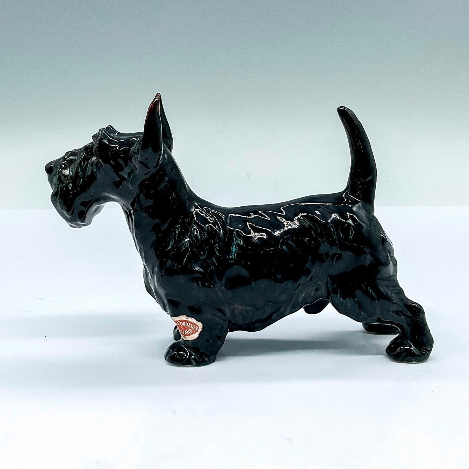 Royal Doulton Bone China Figurine, Scottish Terrier HN1016: Medium dog figure; black coat. Royal Doulton backstamp and sticker. Artist: Fredrick Daws Issued: c. 1931-1960 Dimensions: 5.25"L x 1.75"W x 3.5"H Manufacturer: Royal Doulton Country of Origin: E