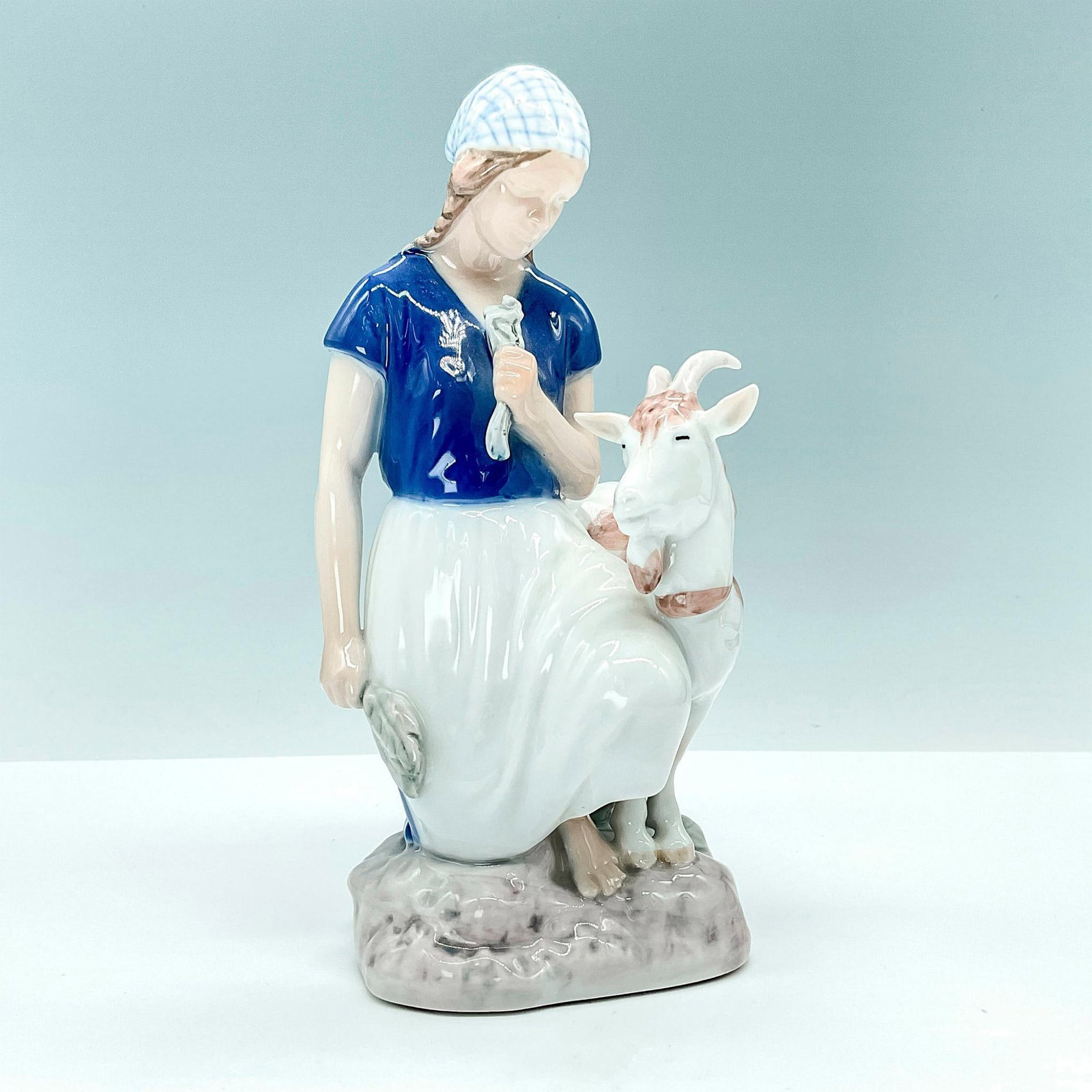 Bing and Grondahl Porcelain Figurine, Girl with Goat: Elegant glossy porcelain figurine portraying a girl with a goat # 2180. Bing and Grondahl backstamp. Artist: Axel Locher Issued: 20th Century Dimensions: 4.5"L x 4"W x 7.75"H Manufacturer: Bing & Gron