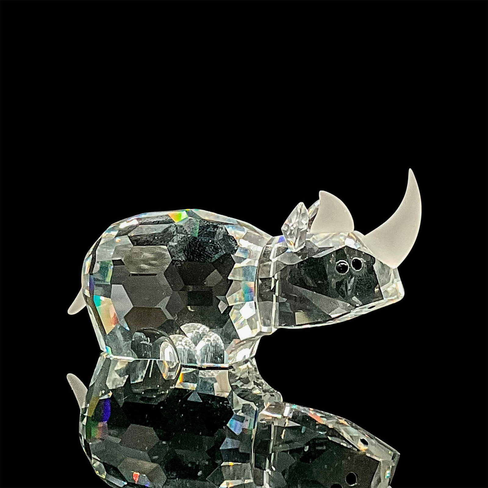 Swarovski Silver Crystal Figurine, Rhinoceros: Clear crystal with opaque rhino horn details. Swarovski backstamp. This item has its original box. Box measures: 4.75"H x 3.25" dia. Dimensions: 3"L x 1"W x 1.25"H Manufacturer: Swarovski Country of O