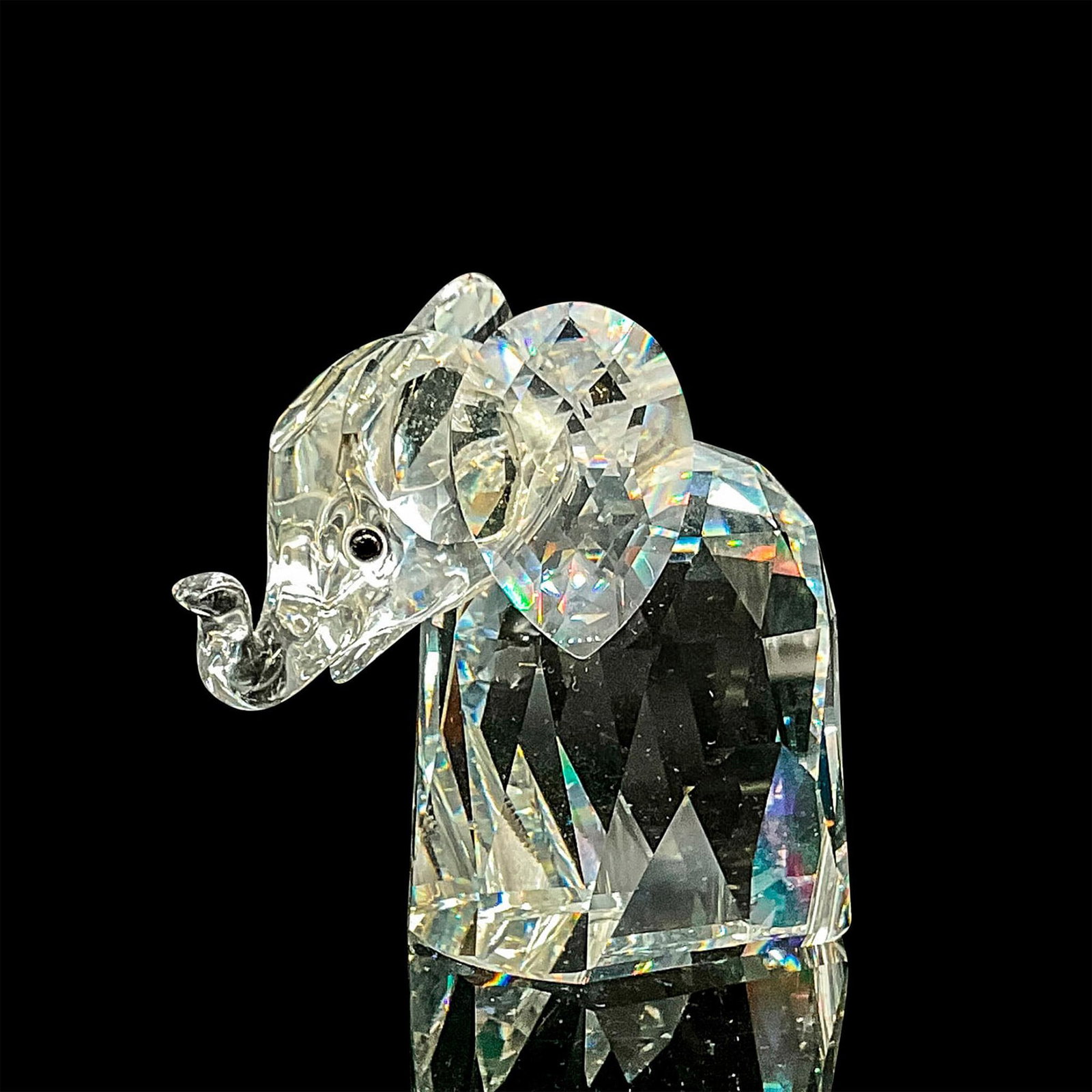 Swarovski Crystal Figurine, Elephant: Clear crystal elephant with metal tail. Swarovski backstamp. This item has its original box. Box measures: 5"H x 4"dia. Dimensions: 3"L x 1.5"W x 2.5"H Manufacturer: Swarovski Country of Origin: Austr