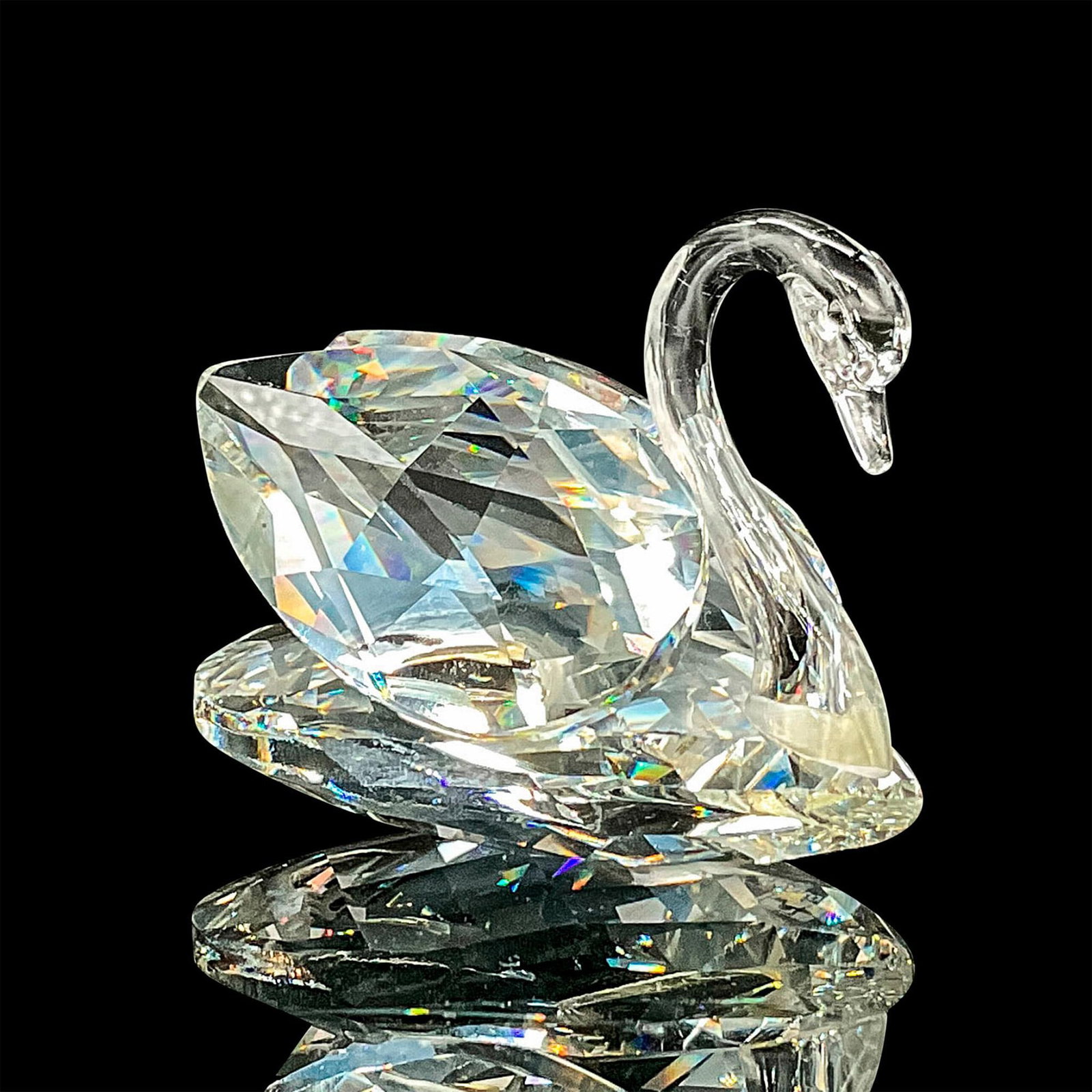 Swarovski Silver Crystal Figurine, Swan: Sleek clear crystal swan with it's head lowered. Swarovski backstamp. This item has its original box. Box measures: 4"H x 5"dia. Dimensions: 2.75"L x 2"W x 2"H Manufacturer: Swarovski Country of Origi