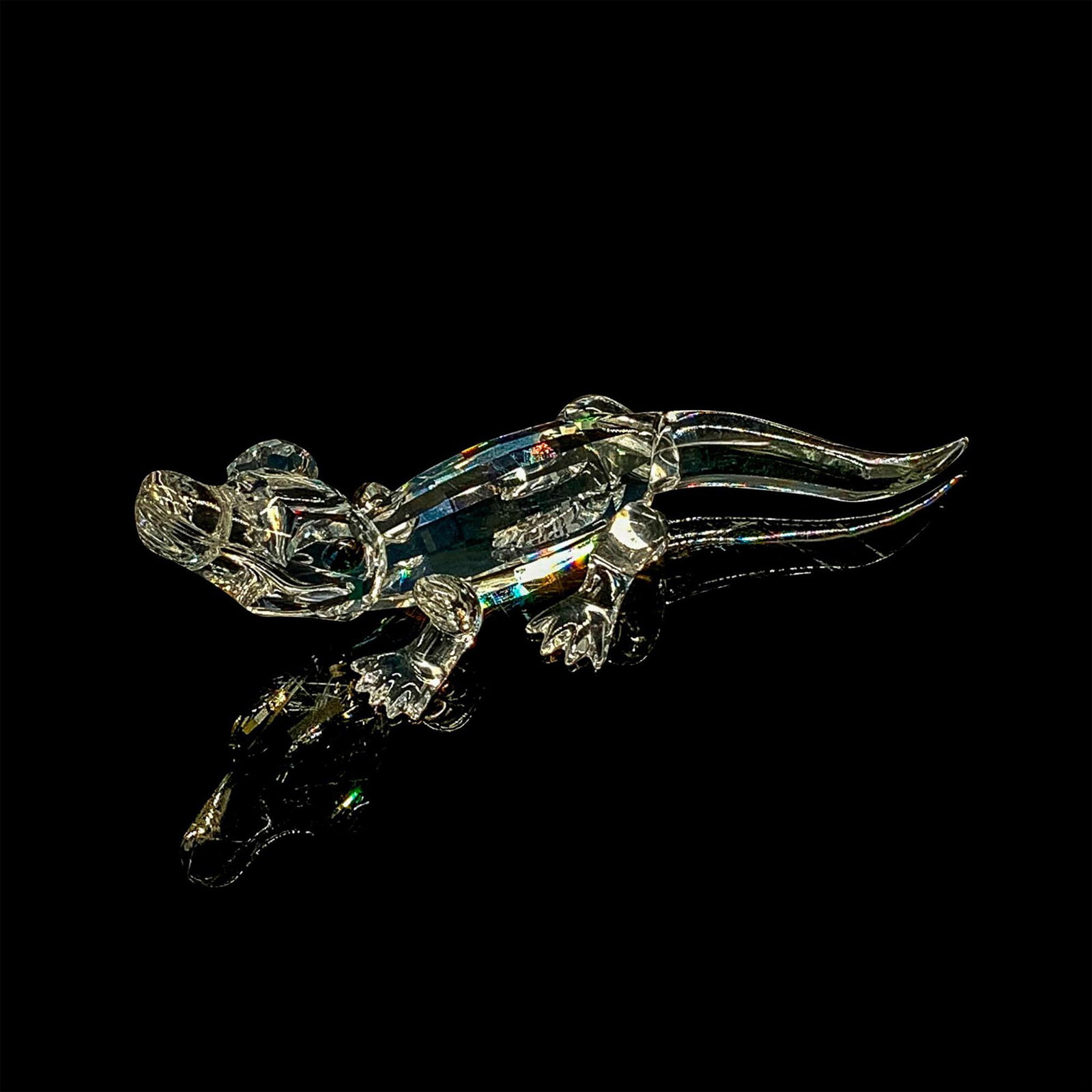 Swarovski Crystal Figurine, Mini Alligator: Miniature alligator facing upwards with clear crystal body. Greenish reptilian crystal eyes with black vertical pupils. Swarovski backstamp. This item has its original box. Dimensions of original box:
