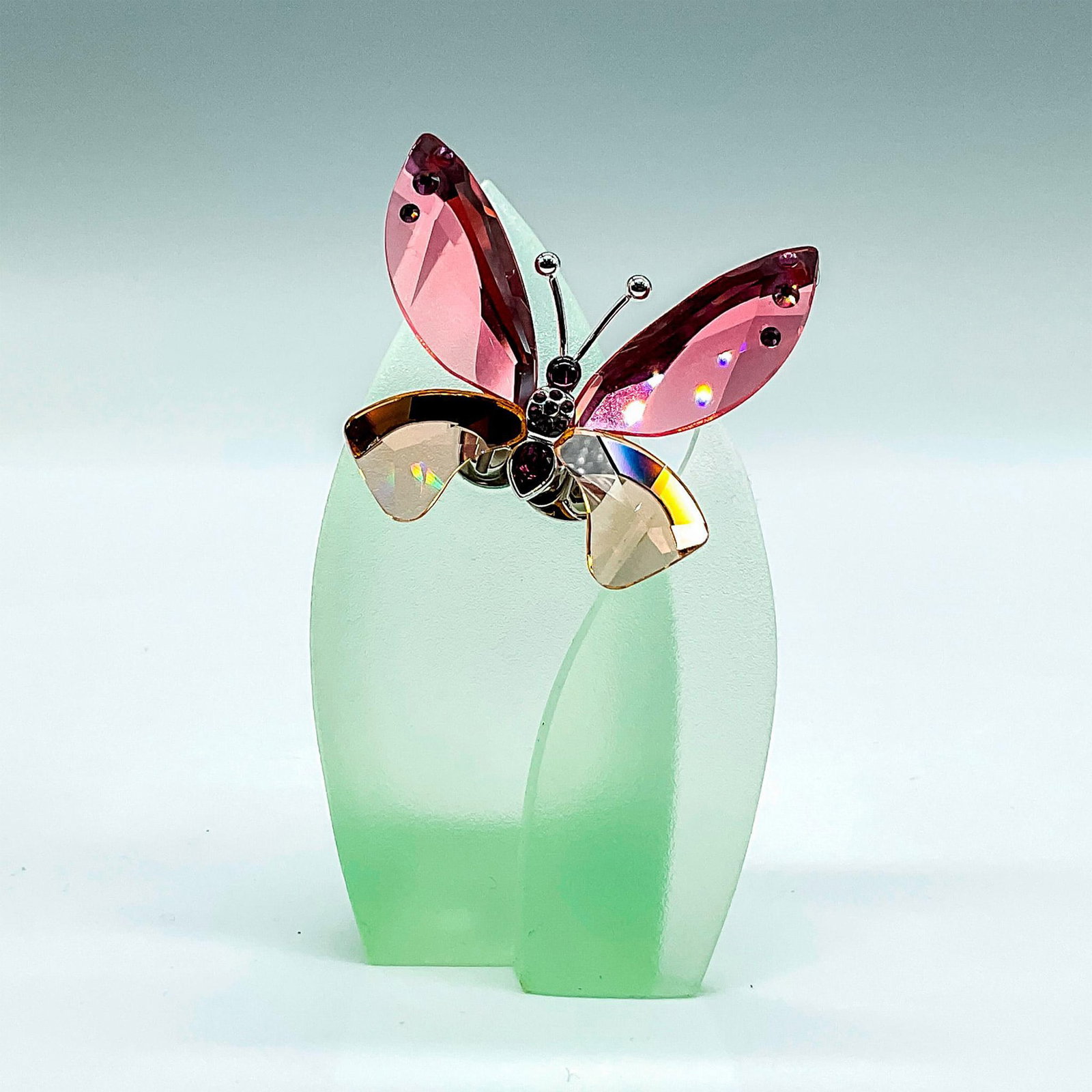 Swarovski Crystal Paradise Butterfly, Azua Padparadscha: Stunning pale pink, peach and purple crystal butterfly attached to a green resin leaf. Butterfly is magnetized and can be removed. Item 719182. Swarovski impressed mark. Includes original box, 4.75"L 