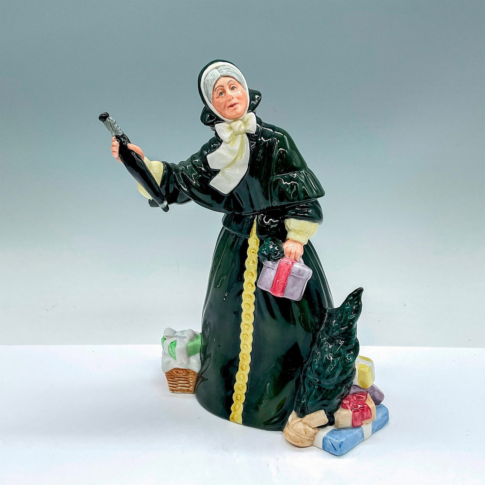 Christmas Parcels - HN2851 - Royal Doulton Porcelain Figurine: Glossy figure of a woman in a dark forest green dress holding a wrapped gifted and umbrella. Royal Doulton backstamp. Artist: William K. Harper Issued: c. 1978-1982 Dimensions: 6.5"L x 5"W x 8.5"H Man