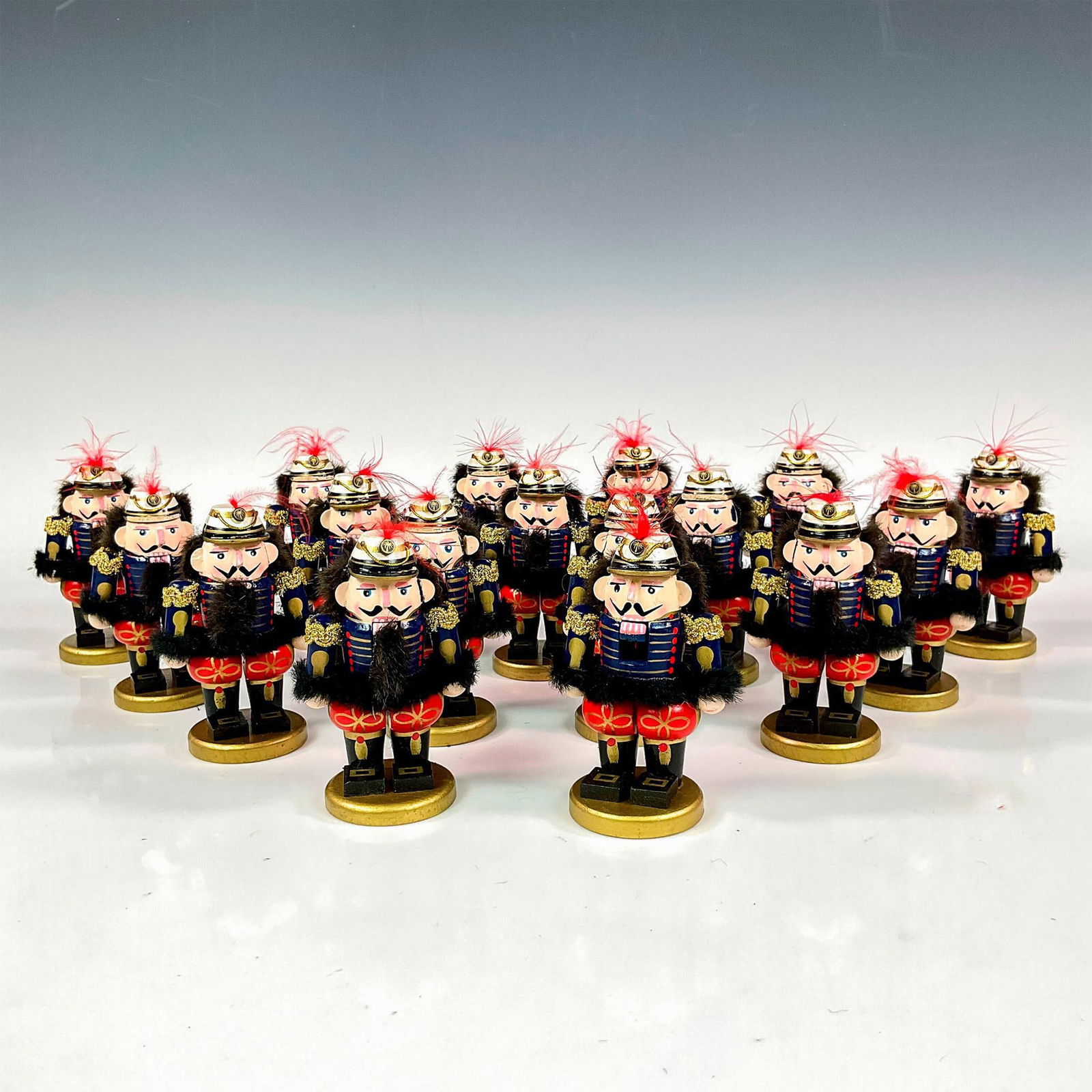 17pc Vintage Wooden Small Nutcrackers: 17 Christmas nutcrackers in a red and blue uniforms with gilded accents, and a white-gilded hat. Each placed on a gilded wooden base. Issued: 20th century Dimensions: 2.5"L x 2"W x 4"H Condition Age r