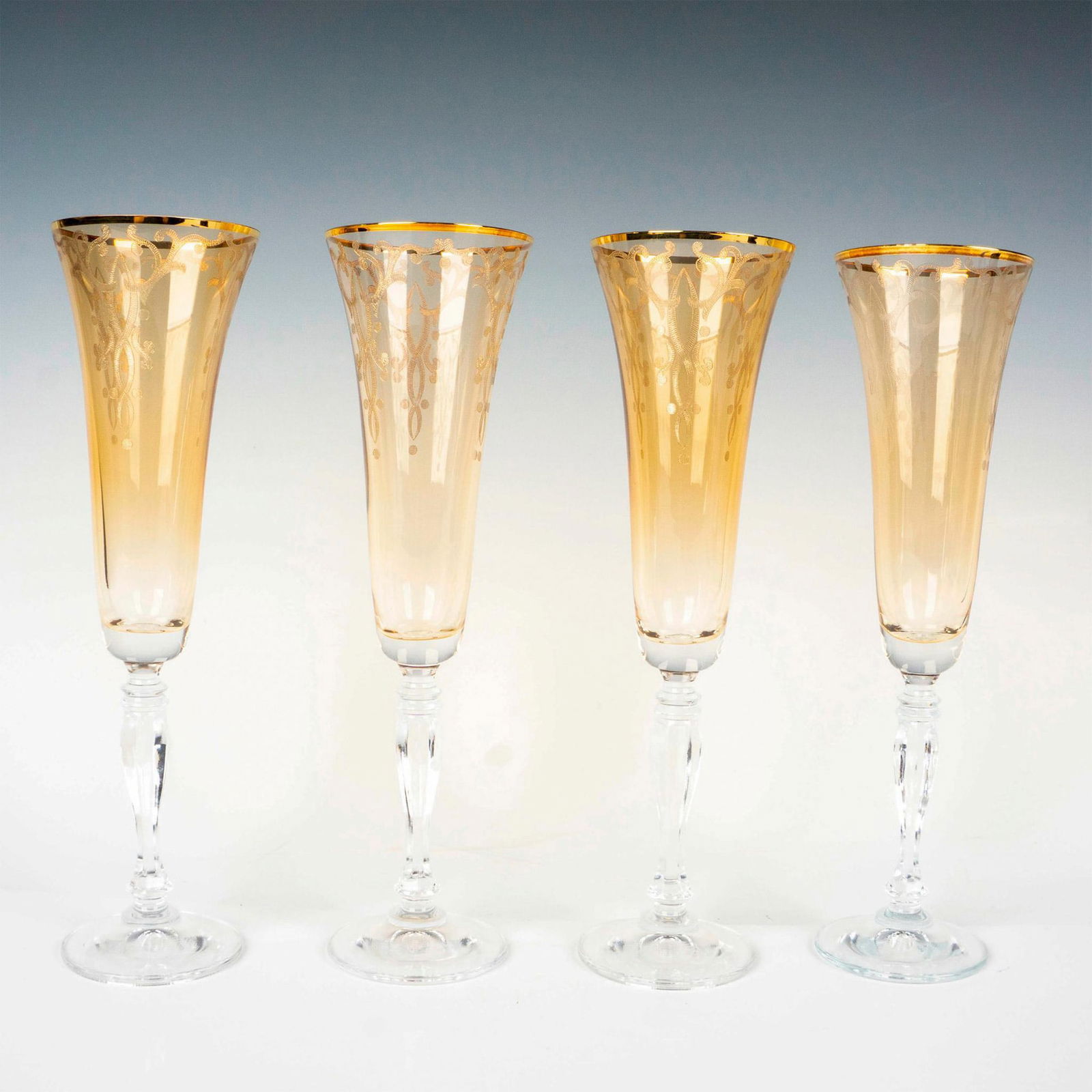 4pc Gold Fluted Champagne Glasses: Amber body with etched design and gilt edge. Issued: 20th century Dimensions: 10"H x 3"dia. Condition Age related wear.