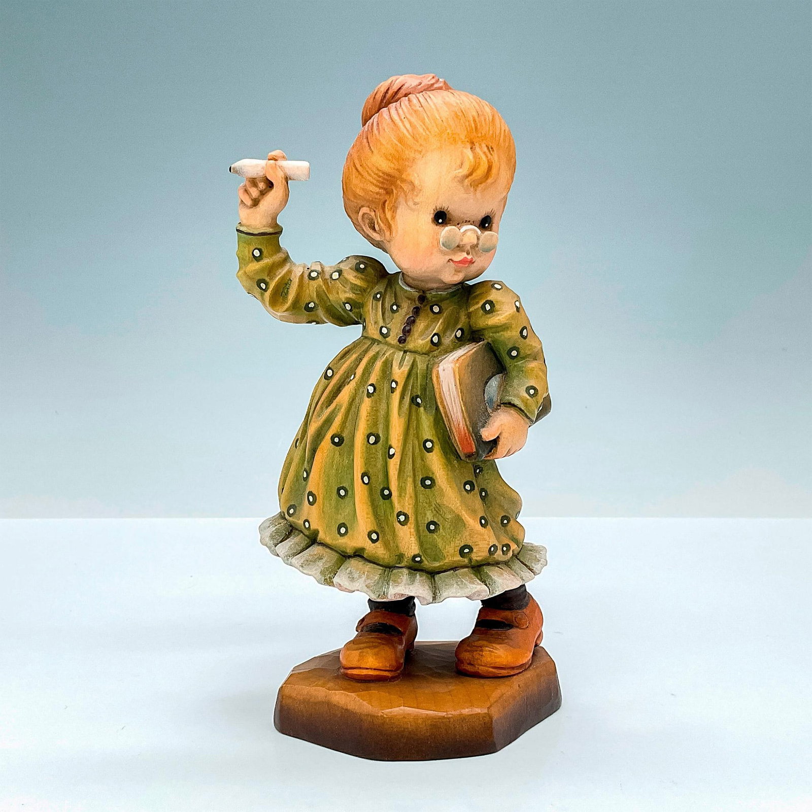 Anri Italy Wood Carved Figurine, School Marm Signed: Adorable painted figure of schoolteacher writing on board. In hues of earthy green, orange, tan and brown. Anri metal logo emblem affixed to base. Design Valentine backstamp. Sarah Kay engraved to bac