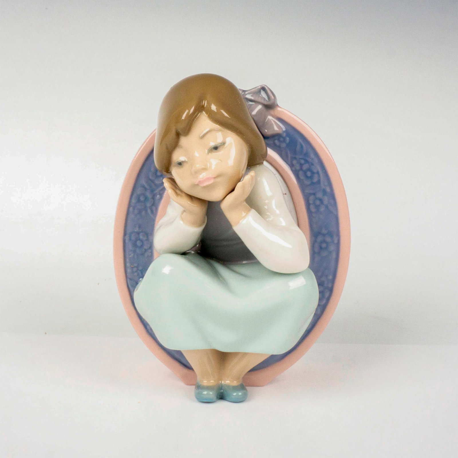 Schoolgirl O 1005148 - Lladro Porcelain Figurine: Glossy finish; Lladro backstamp. Includes original box. Box measures: 7.75"L x 5.25"W x 4.75"H. Artist: Jose Puche Issued: 1982 - 1985 Dimensions: 4.75"H Manufacturer: Lladro Country of Origin: Sp