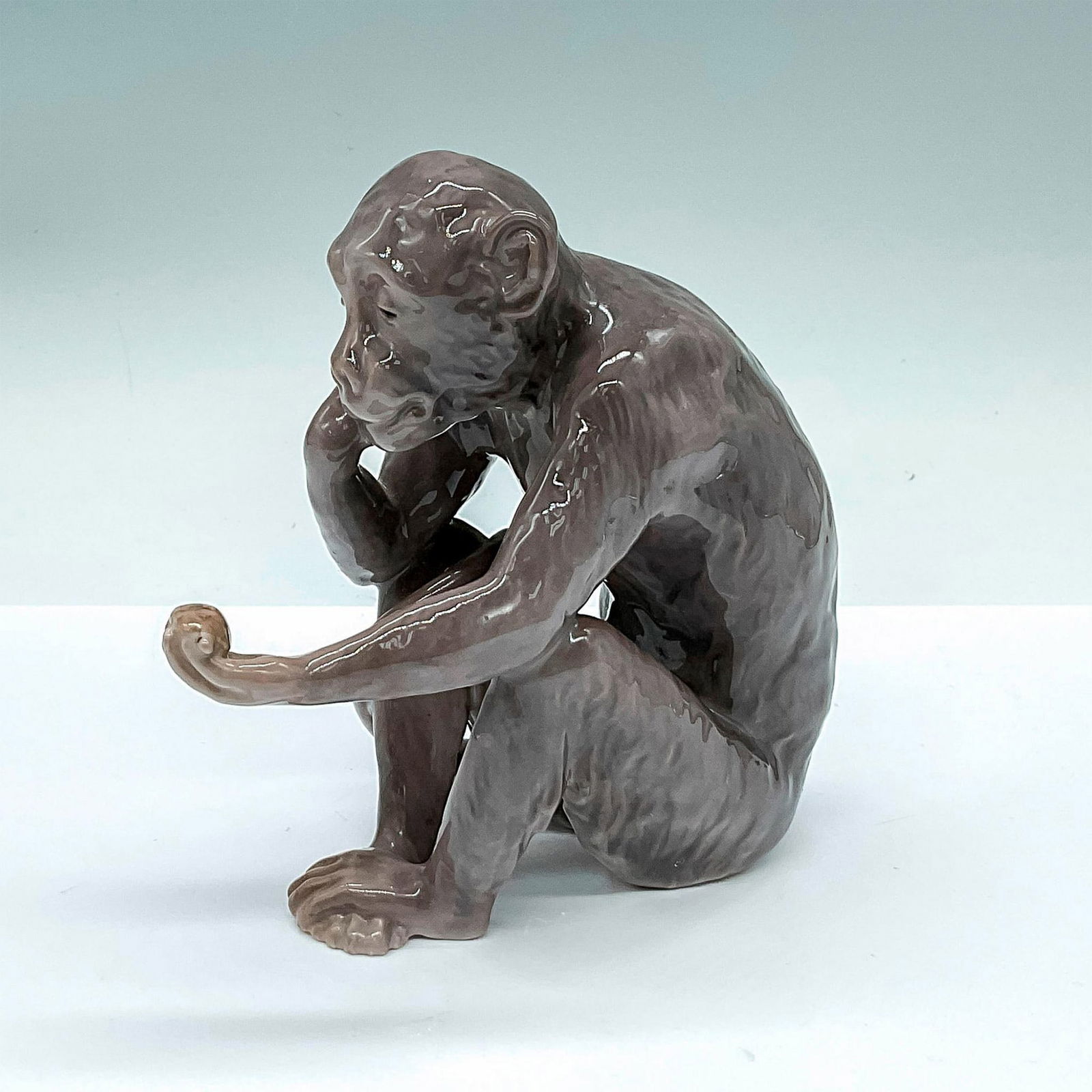 Bing & Grondahl Porcelain Figurine, Monkey with Turtle: Glazed small figure of a gray monkey admiring a small turtle in its' paw. Bing & Grondahl backstamp. Issued: 20th century Dimensions: 5.25"L x 2.75"W x 5"H Manufacturer: Bing & Grondahl Country of Ori