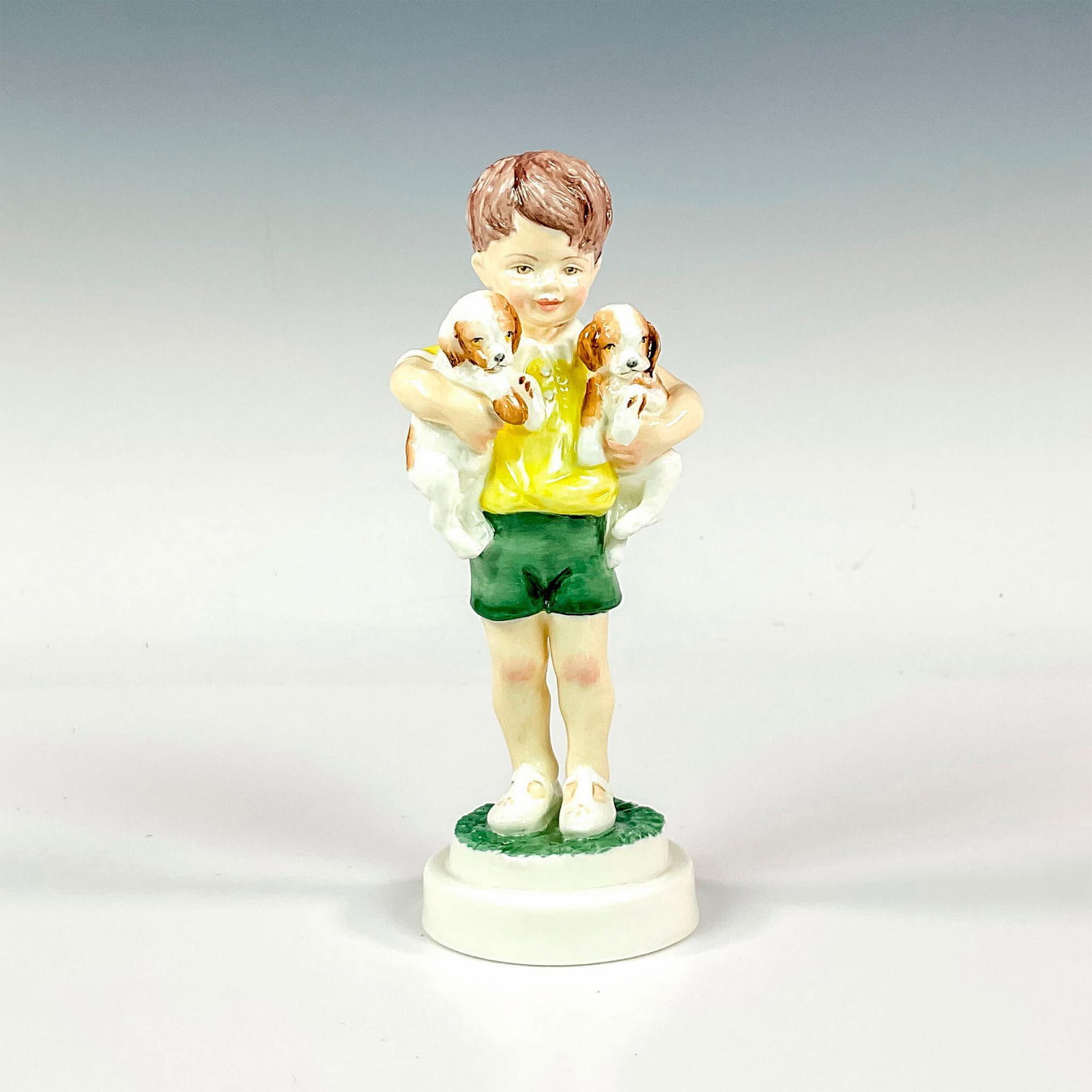 Royal Worcester Figurine, All Mine 3519: Glossy finish modeled as a little boy child dressed in buttercup yellow shirt and green summer shorts holding two little puppies. Royal Worcester backstamp. Artist: F. G. Doughty Issued: c. 1950 Dimen