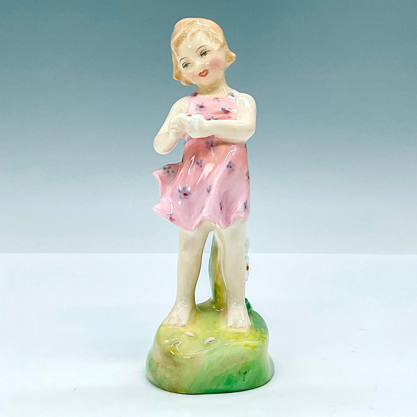 He Loves Me HN2046 - Royal Doulton Figurine: Nursery Rhymes series, modeled as a young girl with white flower in hand. Royal Doulton backstamp. Artist: Leslie Harradine Issued: 1949-1962 Dimensions: 2"L x 2"W x 5.5"H Manufacturer: Royal Doulton