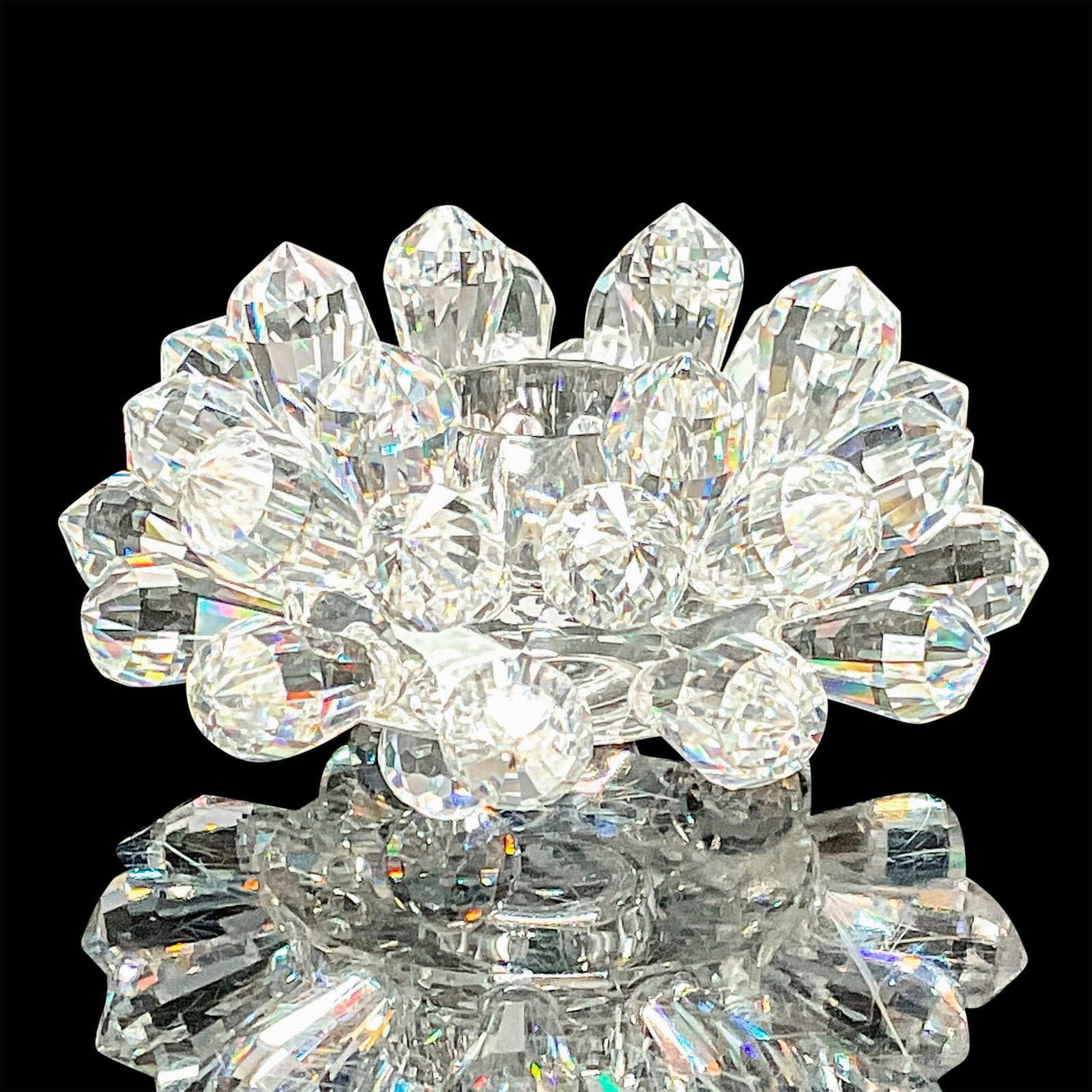 Asfour Crystal Candleholder: Stunning candle holder in the shape of a blossoming flower or dazzling starburst with space in the center for a single candle. Asfour etched backstamp. Dimensions: 3"L x 3"W x 1.5"H Manufacturer: Asfo