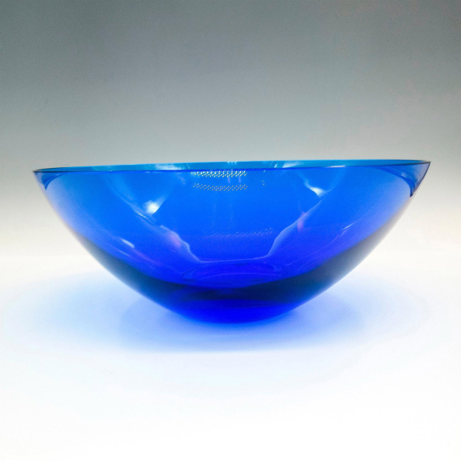 Lalique Blue Glass Bowl: Beautiful cobalt blue color with smooth design. Lalique etched backstamp. Issued: 20th century Dimensions: 3.75"H x 8.5"dia. Country of Origin: France Manufacturer: Lalique Provenance: Collection