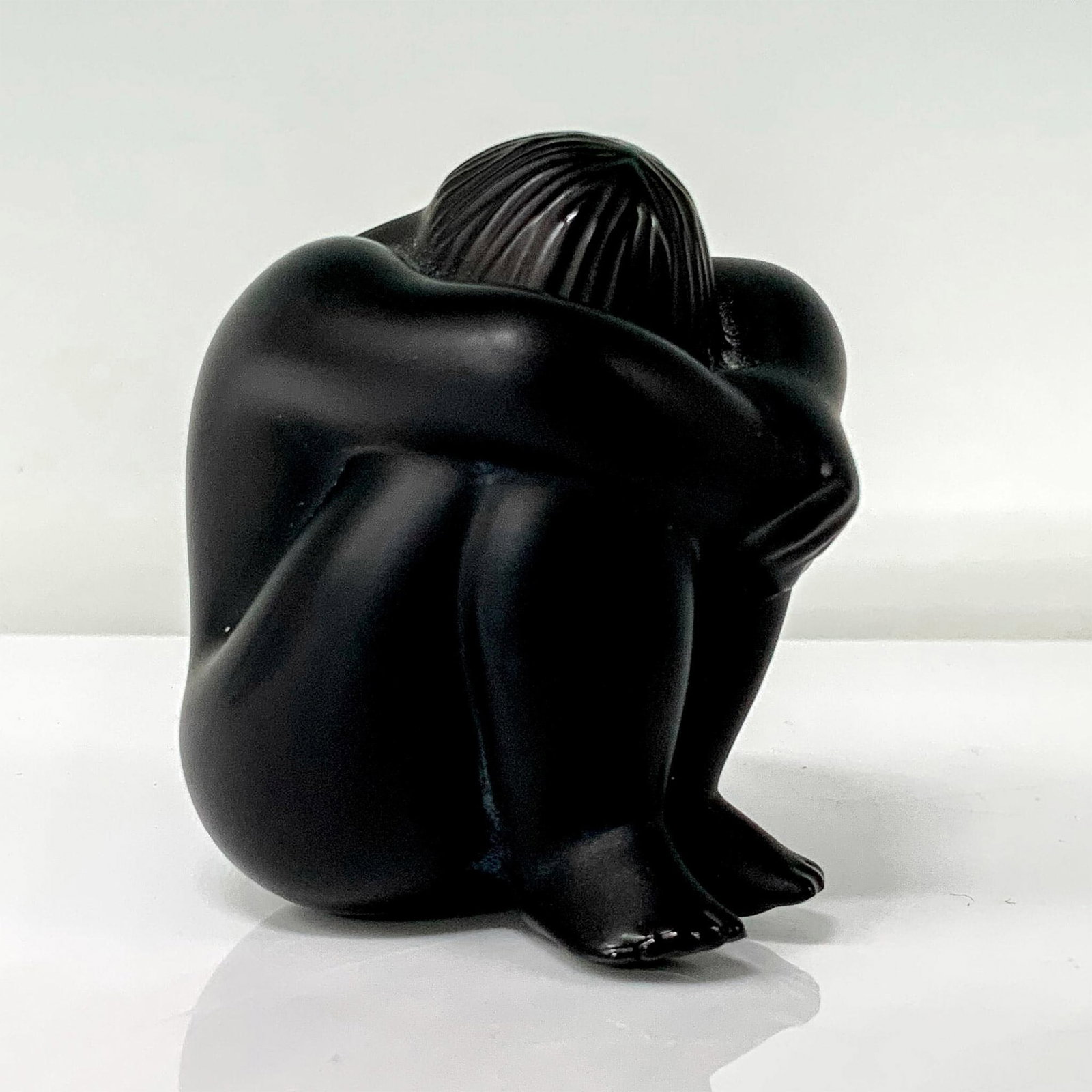 Lalique Black Crystal Nu Nahbi Figure: A crystal figure of a nude person sitting down with their arms and legs covering their head. Signed Lalique France. Dimensions: 2"L x 2"W x 2.25"H Country of Origin: France Manufacturer: Lalique Prove