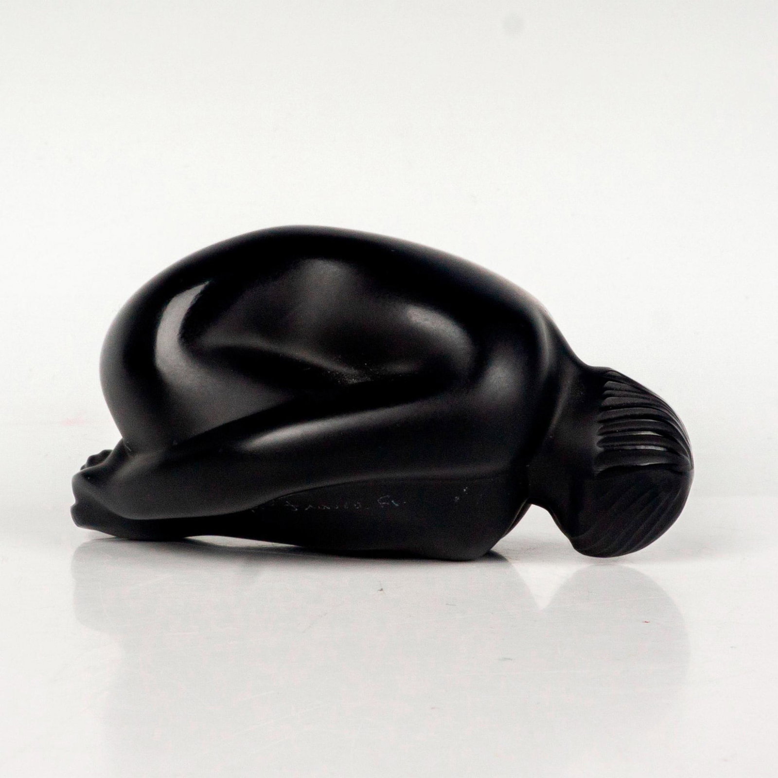 Lalique Crystal Noir Figurine, Nu Reve Resting: Figure of a person in a child pose. Nude series of a body a in various static poses. Noir glass art. Etched Lalique France. Dimensions: 3.25" x 3.25"W x 2"H Country of Origin: France Manufacturer: Lal