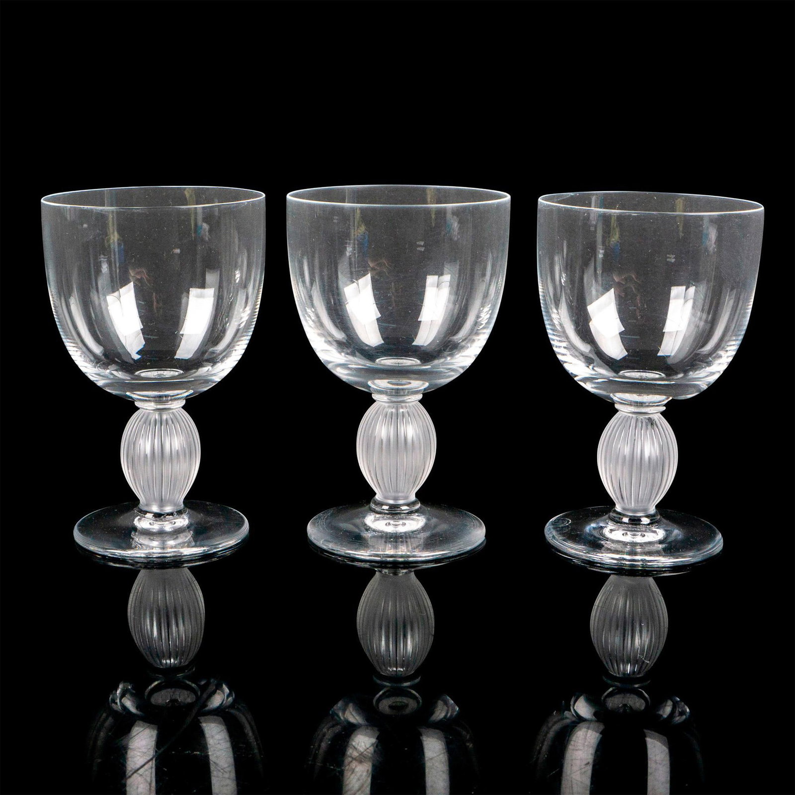 3pc Lalique Crystal Bordeaux Wine Glasses, Langeais: Clear body with vertical frosted ribbed stem. Lalique etched mark. Artist: Marc Lalique Dimensions: 3"L x 3"W x 4.75"H Country of Origin: France Manufacturer: Lalique Provenance: Collection of Ma