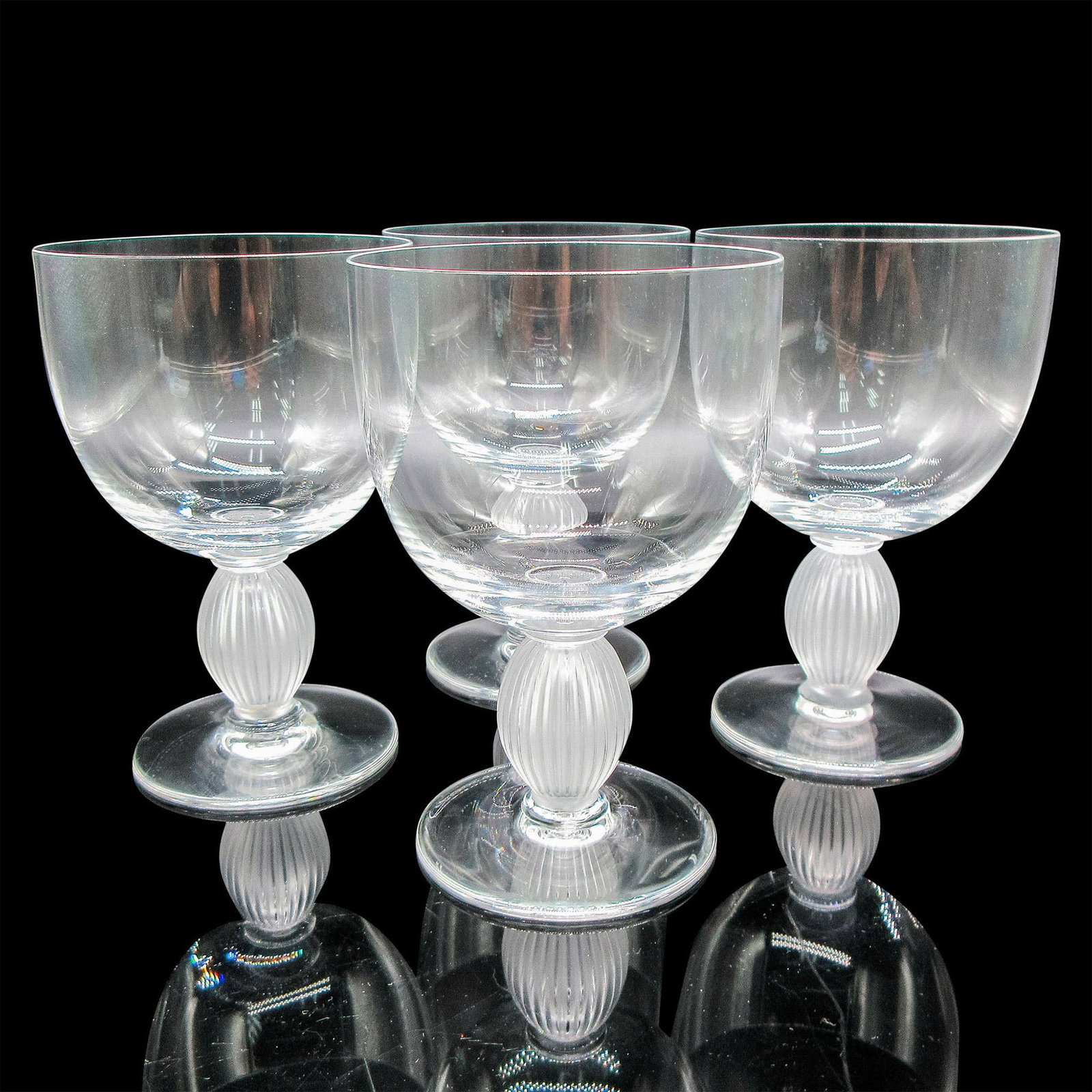 4pc Lalique Crystal Bordeaux Wine Glasses, Langeais: Clear body with frosted vertical ribbed stem. Lalique etched mark. Artist: Marc Lalique Dimensions: 3.25"L x 3.25"W x 5"H Country of Origin: France Manufacturer: Lalique Provenance: Collection of