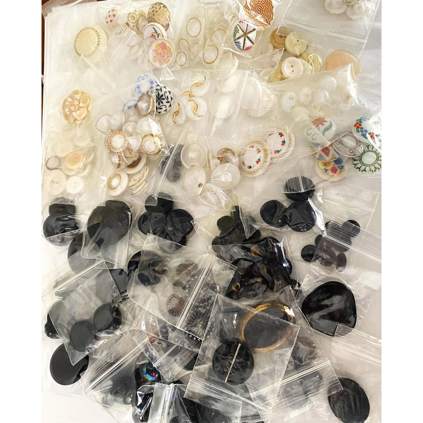 A Bag Lot of Assorted Buttons: A selection of assorted black glass & white glass buttons. These bag lots and the next 3 came to us from a consignor that had already bagged the buttons in sets and look a-likes, so we have left them 