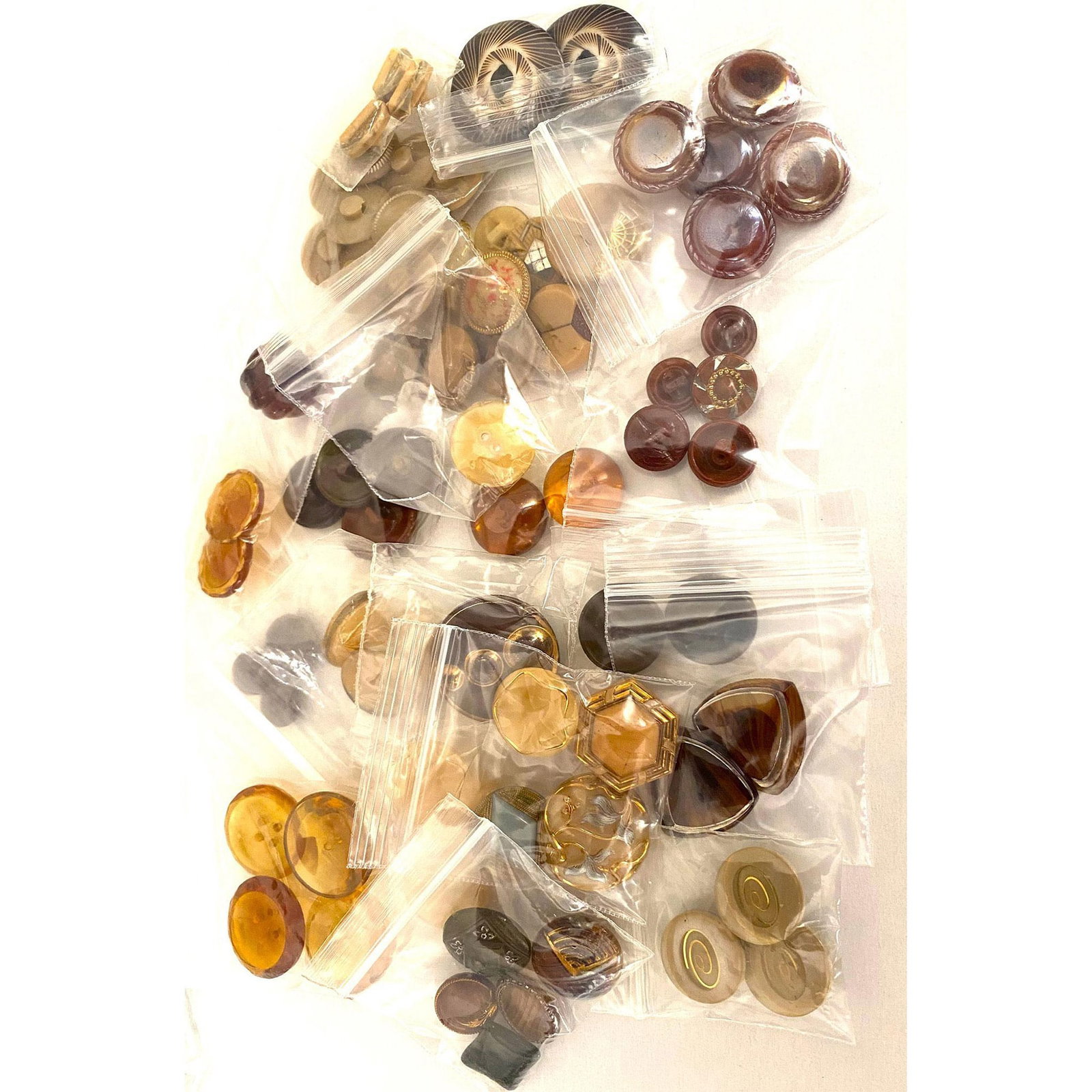A Bag Lot of Assorted Buttons: A variety of assorted brown and shades of brown of glass buttons. These bag lots and the next one came to us from a consignor that had already bagged the buttons in sets and look a-likes, so we have l