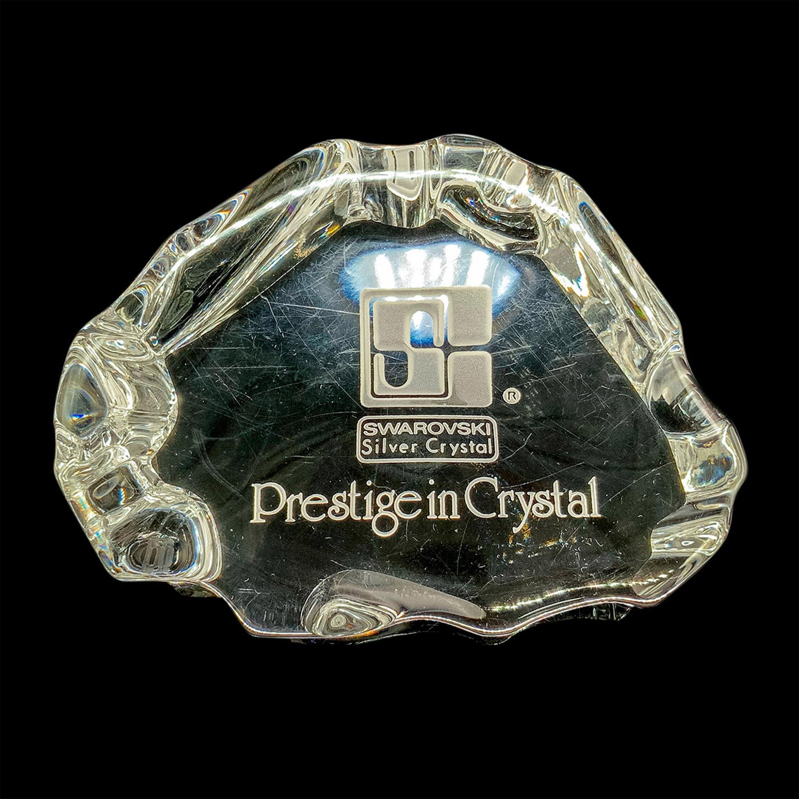 Swarovski Prestige in Crystal Paperweight: Silver crystal paperweight engraved with Swarovski stamp and the words Prestige in Crystal. Dimensions: 4"L x 3"W x 1"H Manufacturer: Swarovski Country of Origin: Austria