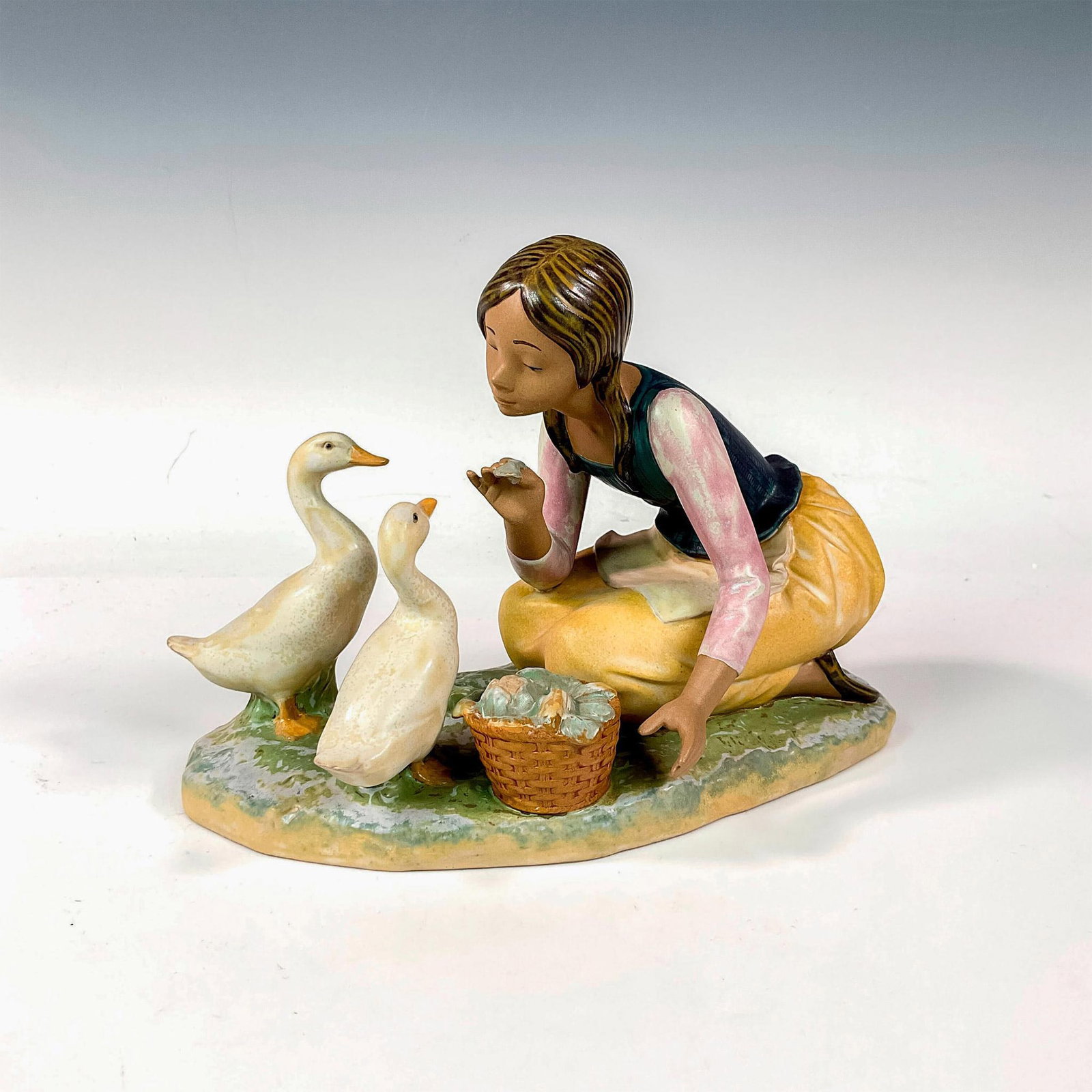 Feeding The Ducks 1012346 - Lladro Porcelain Figurine: Gres finish; Lladro backstamp. Artist: Alfredo Ruiz Issued: 1996 - 1999 Dimensions: 6.75"H x 9.5"W Manufacturer: Lladro Country of Origin: Spain
