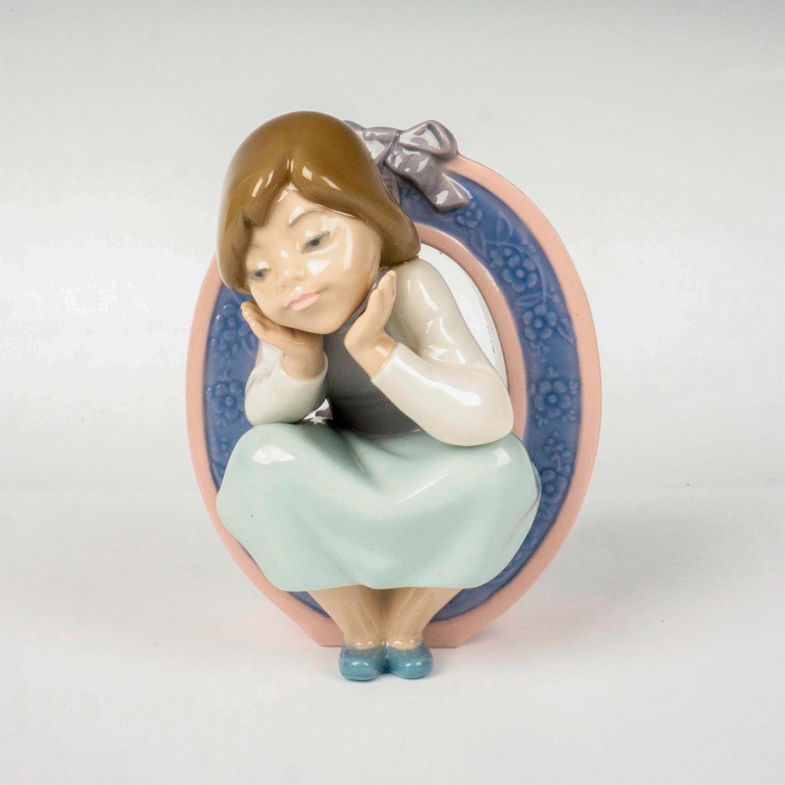 Schoolgirl O 1005148 - Lladro Porcelain Figurine: Glossy finish; Lladro backstamp. Includes original box. Box measures: 7.75"L x 5.25"W x 4.75"H. Artist: Jose Puche Issued: 1982 - 1985 Dimensions: 4.75"H Manufacturer: Lladro Country of Origin: Sp