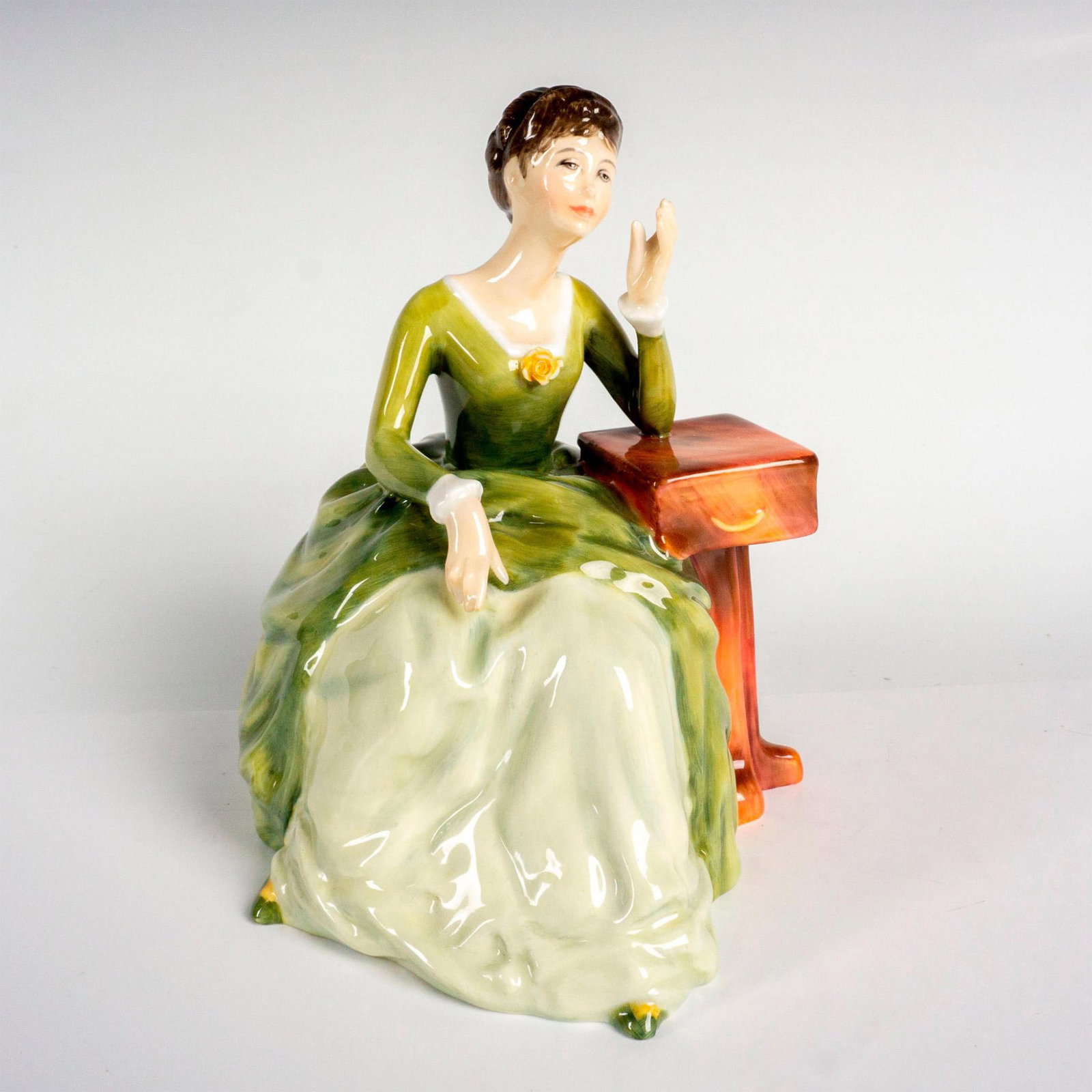 Carolyn - HN2974 - Royal Doulton Figurine: Classic Pretty Ladies collection; seated lady wearing a green layered gown. Royal Doulton backstamp. Artist: Amanda Hughes Issued: 1982 Dimensions: 5.5"H Manufacturer: Royal Doulton Country of Origin