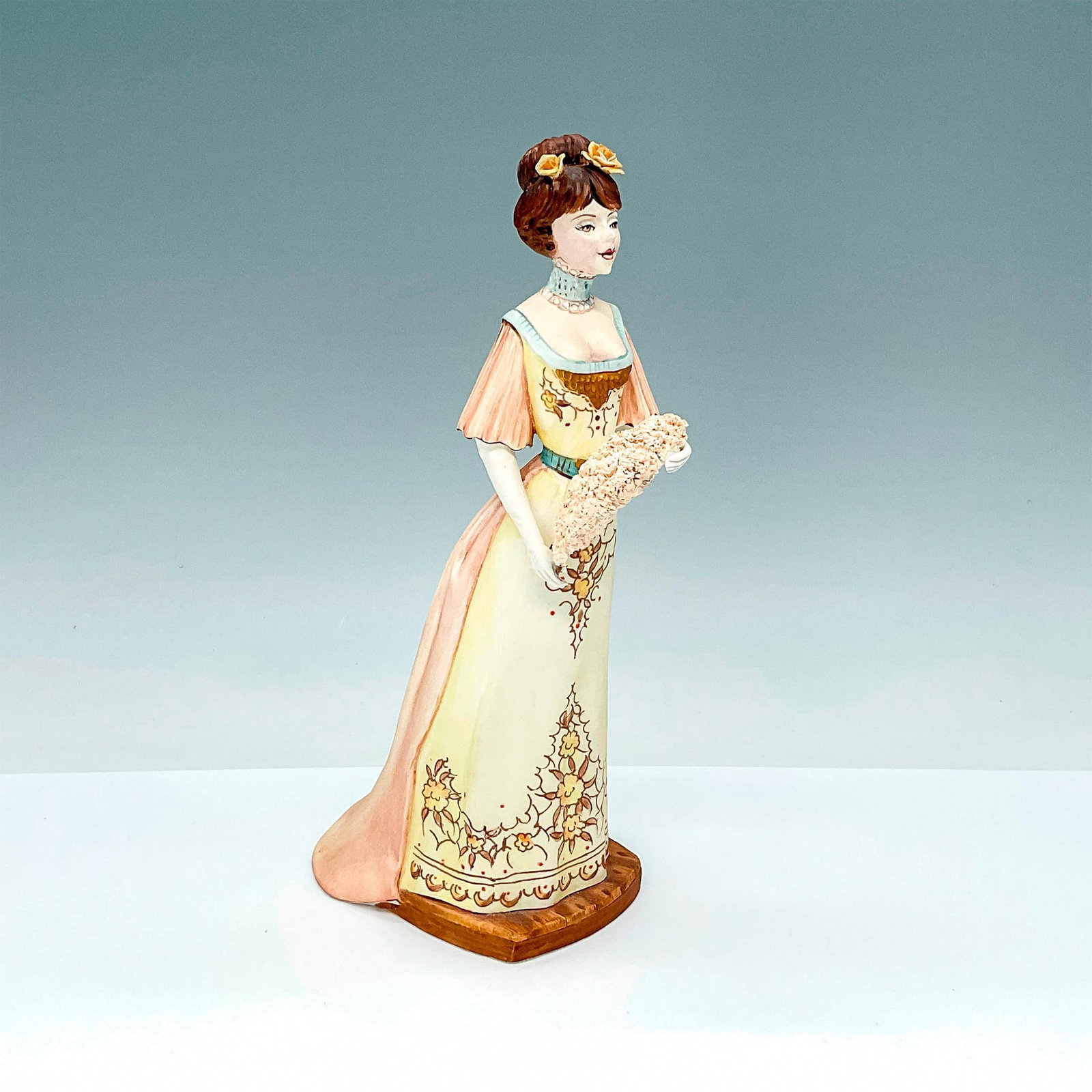 Albany Fine China Co. Figurine, Georgina: This fine china figurine is part of the Edwardian Services collection and is modeled after a refined lady dressed in her exquisite cream-colored dress, holding a feather capturing the elegance of the 