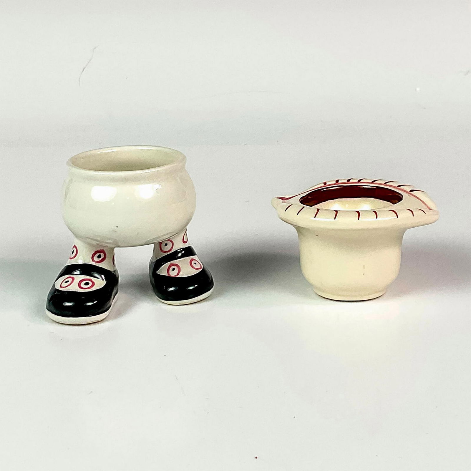 2pc Carlton Ware Mini Breakfast Set: Includes a ceramic footed character egg cup with comical feet. Also includes a salt cellar with hand drawn eye. Vintage hand painted items. Egg cup measures: 2.75"L x 2.75"W x 2.5"H. Salt cellar measu