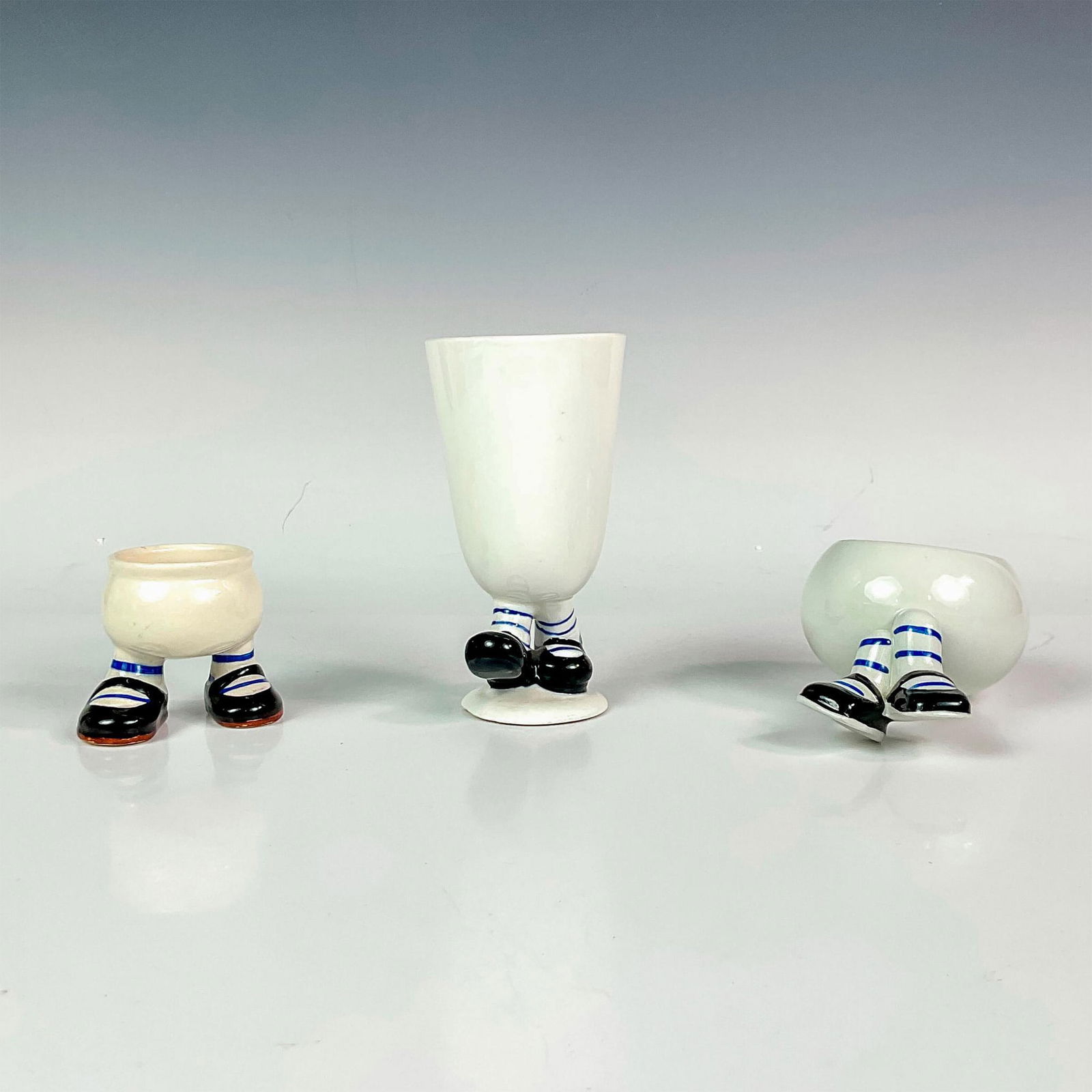 3pc Carlton Ware Ceramic Breakfast Set: Includes a ceramic footed character egg cup, juice cup, and fruit bowl with comical feet. Vintage hand painted items. Egg cup measures: 2.75"L x 2.75"W x 2.5"H. Juice cup measures: 5.25"H x 2.75"dia.