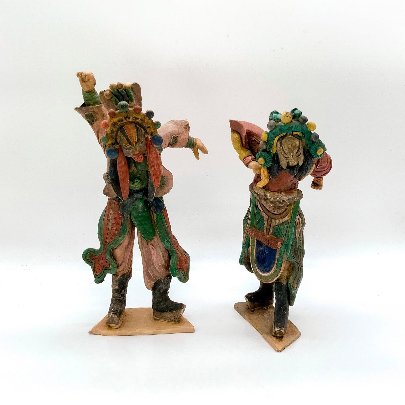 Pair of Asian Classic Theater Actor Figurines: Depicts two men wearing colorful costumes and elaborate headdresses in dramatic poses. Dimensions of tallest: 4.5 in. L x 3.5 in. W x 9.5 in. H.