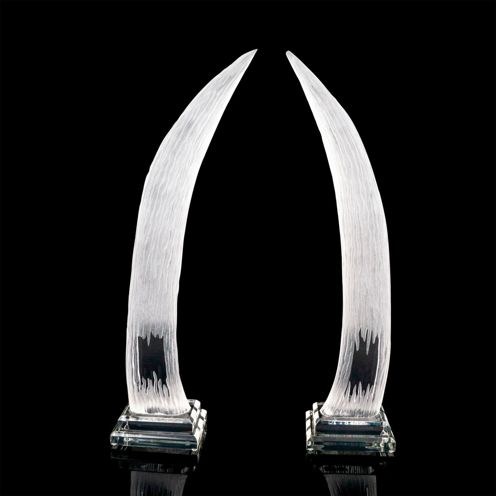 Pair of Hivo Van Teal Lucite Tusk Sculptures: A set of two carved frosted to clear acrylic tucks attached to a clear base. Van Teal etched on the bases. Artist: Hivo Van Teal Issued: Late 20th century Dimensions: 9"L x 5.25"W x 26.25"H Country of