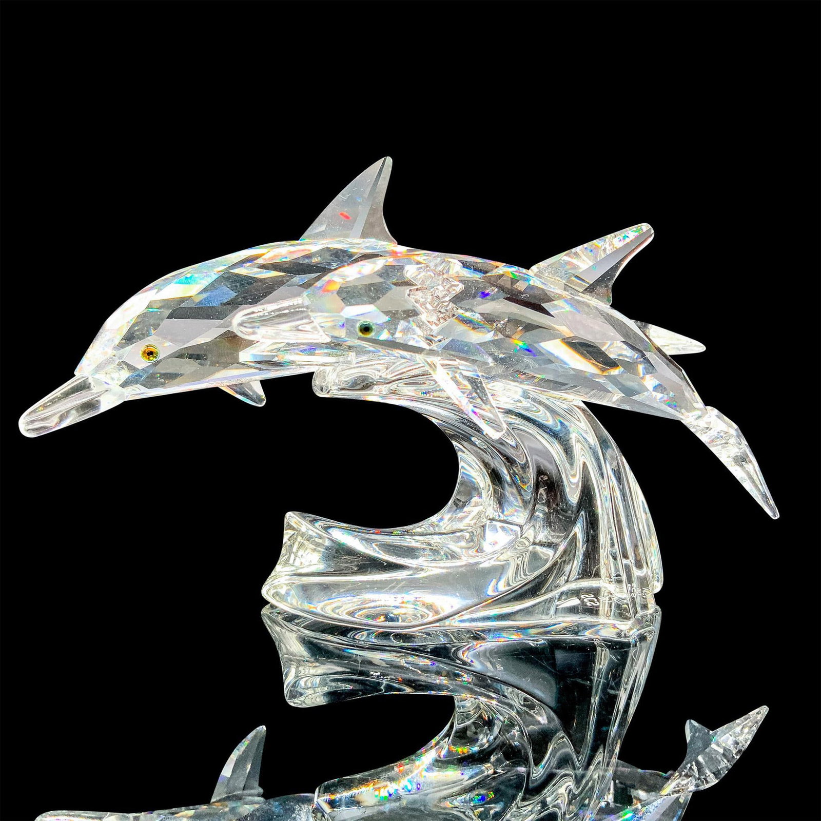Lead Me 153850 - Swarovski Crystal Figurine: A clear crystal figurine of a mother dolphin and her child riding a wave together with melon colored crystal for their eyes. Swarovski SCS backstamp. Artist: Michael Stamey Issued: 1990 Dimensions: 5"