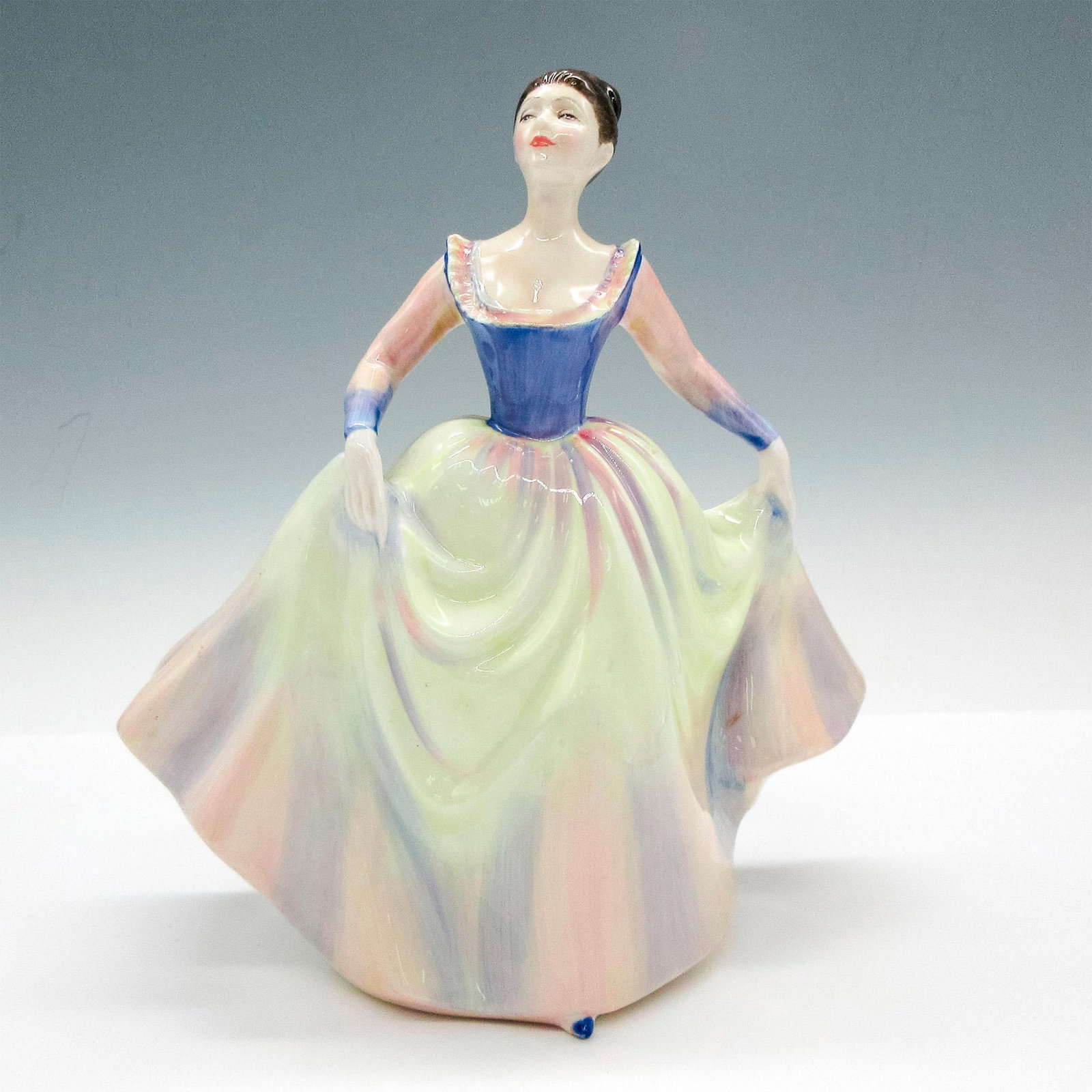 Lisa HN2394 - Royal Doulton Figurine: Glazed figural in multicolored gown. Royal Doulton backstamp. Artist: Peggy Davies Issued: 1983-1990 Dimensions: 6.5"L x 4"W x 8"H Manufacturer: Royal Doulton Country of Origin: England