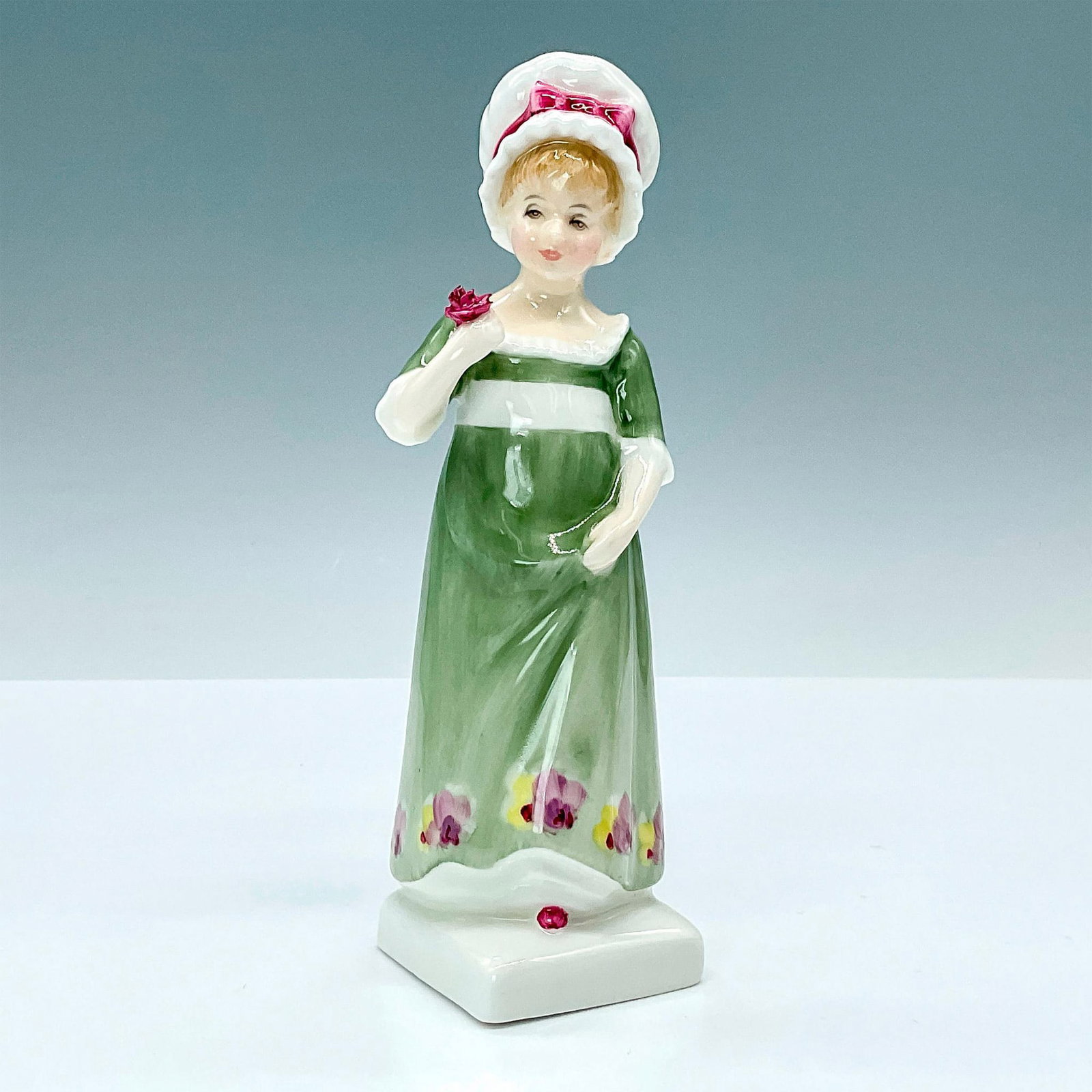 Ruth HN2799 - Royal Doulton Figurine: Lovely young Ruth in a green high waisted dress waisted dress holding a red rose. Kate Greenaway was a children's book illustrator and writer. Her first book, Under the Window, a collection of simple,