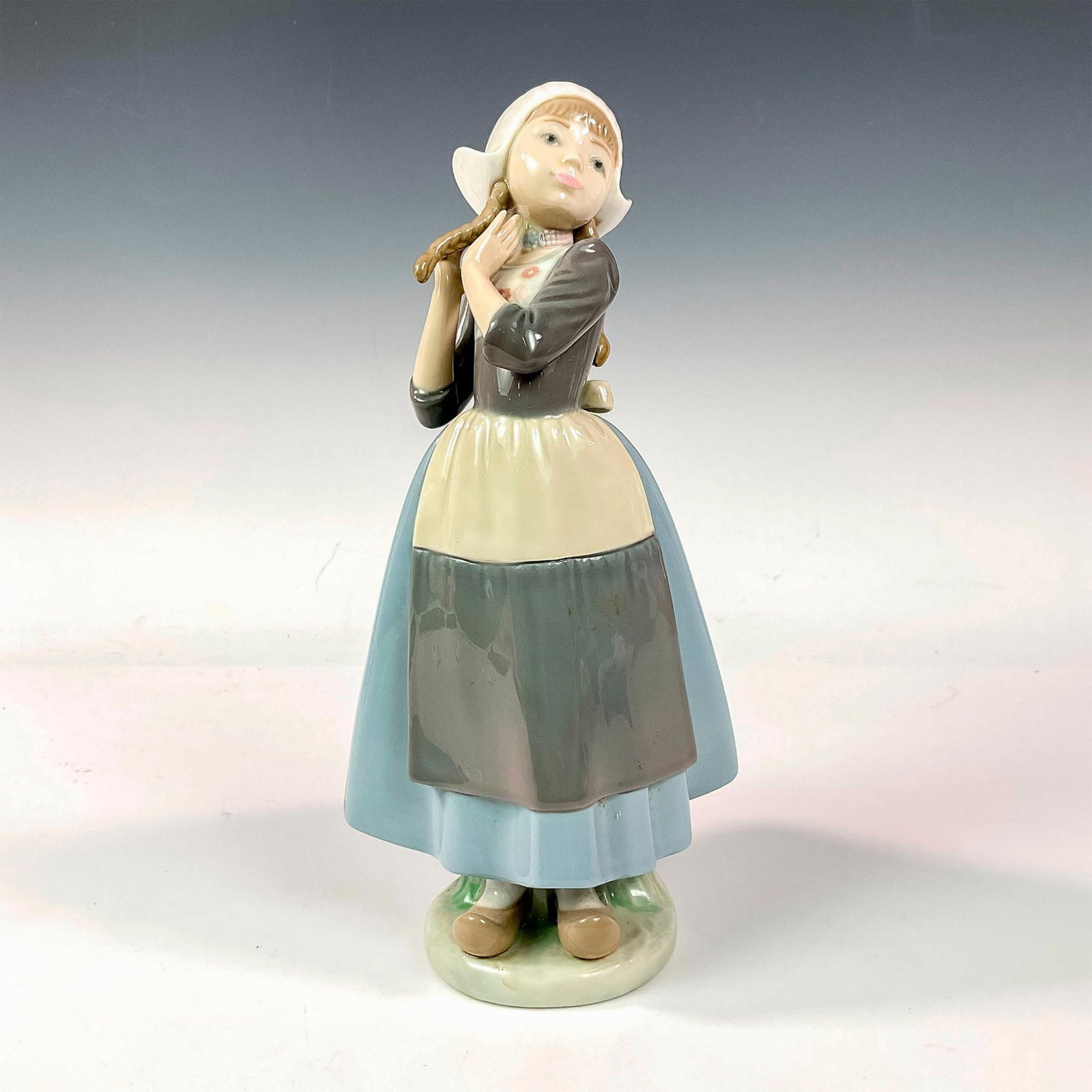 Dutch Girl With Braids 1005063 - Lladro Porcelain Figurine: Glossy finish; Lladro backstamp. Artist: Francisco Catala Issued: 1980 - 1985 Dimensions: 9.75"H Manufacturer: Lladro Country of Origin: Spain