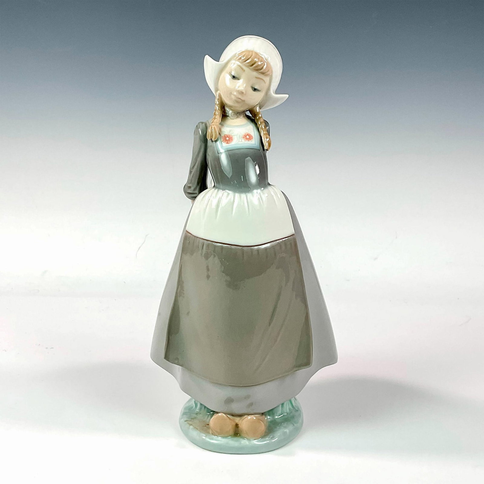 Dutch Girl, Kristina 1005062 - Lladro Porcelain Figurine: Glossy finish; Lladro backstamp. Artist: Francisco Catala Issued: 1980 - 1985 Dimensions: 10"H Manufacturer: Lladro Country of Origin: Spain