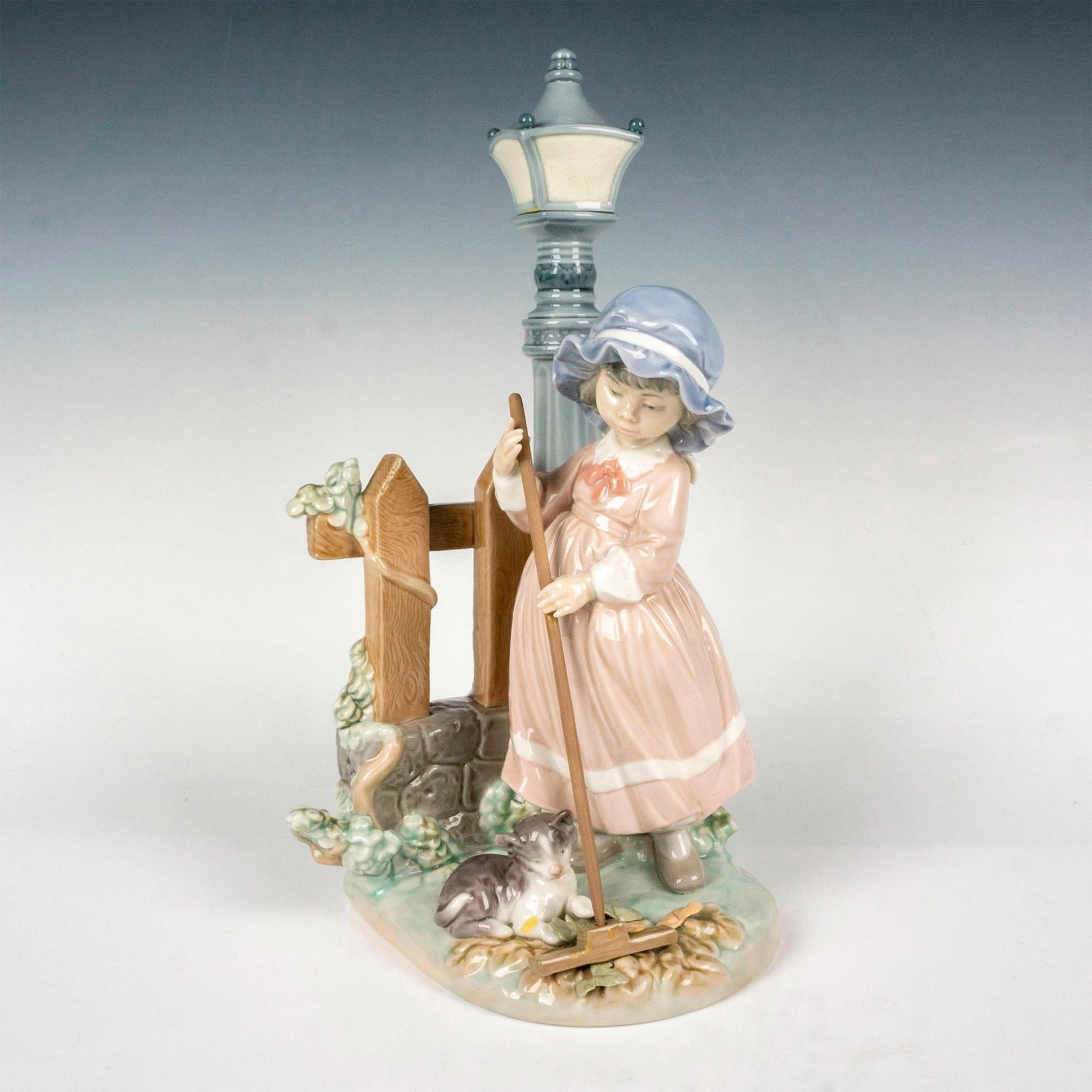 Fall Clean Up 1005286 - Lladro Porcelain Figurine: Glossy finish; Lladro backstamp. Artist: Antonio Ramos Issued: 1985 - 2007 Dimensions: 13"H x 6.5"W Manufacturer: Lladro Country of Origin: Spain