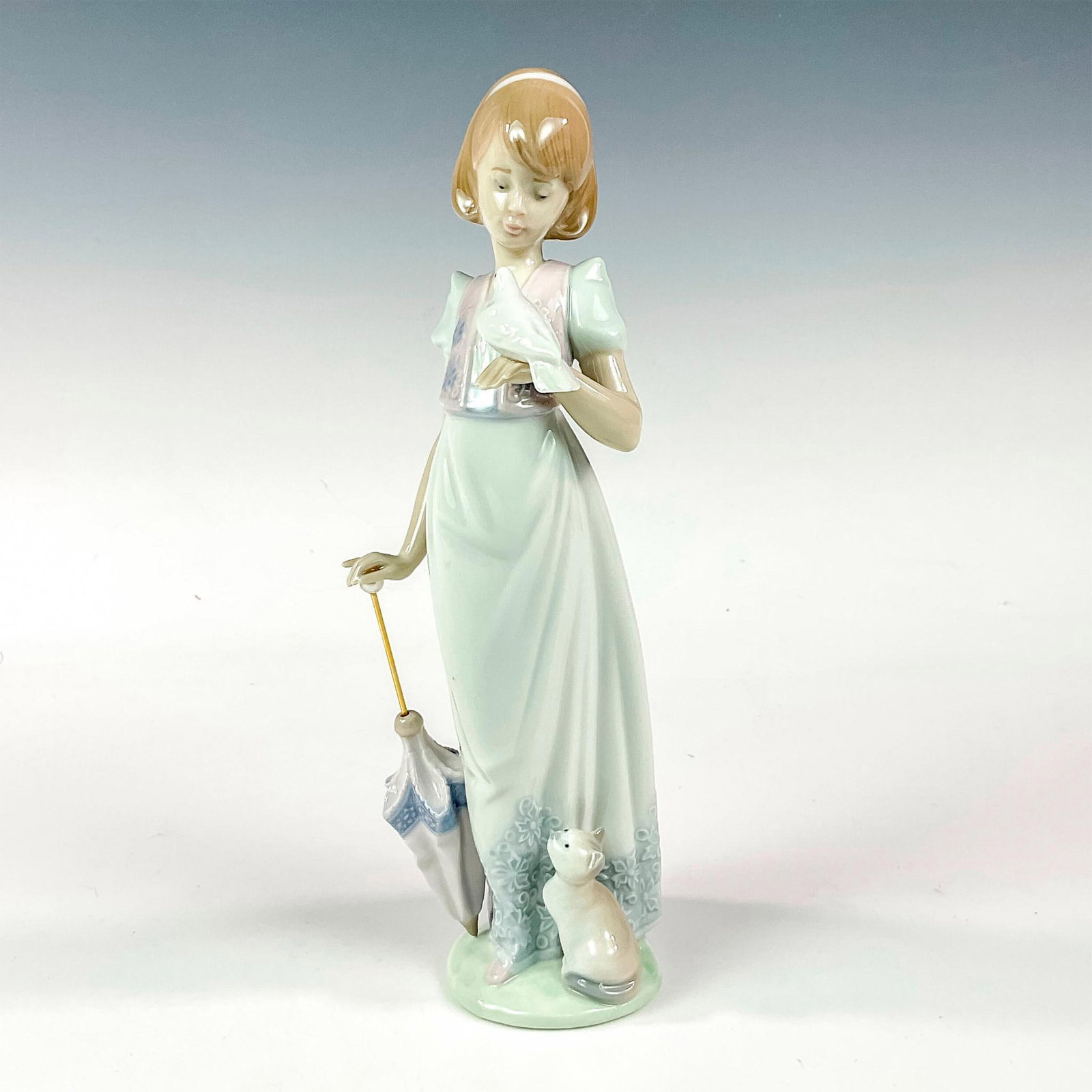 Summer Stroll 1007611 - Lladro Porcelain Figurine: Glossy finish; Lladro backstamp. This item has its original box: 11"L x 5.75"W x 5"H. Artist: Juan Huerta Issued: 1991 Dimensions: 3.25"W x 9.5"H Manufacturer: Lladro Country of Origin: Spain