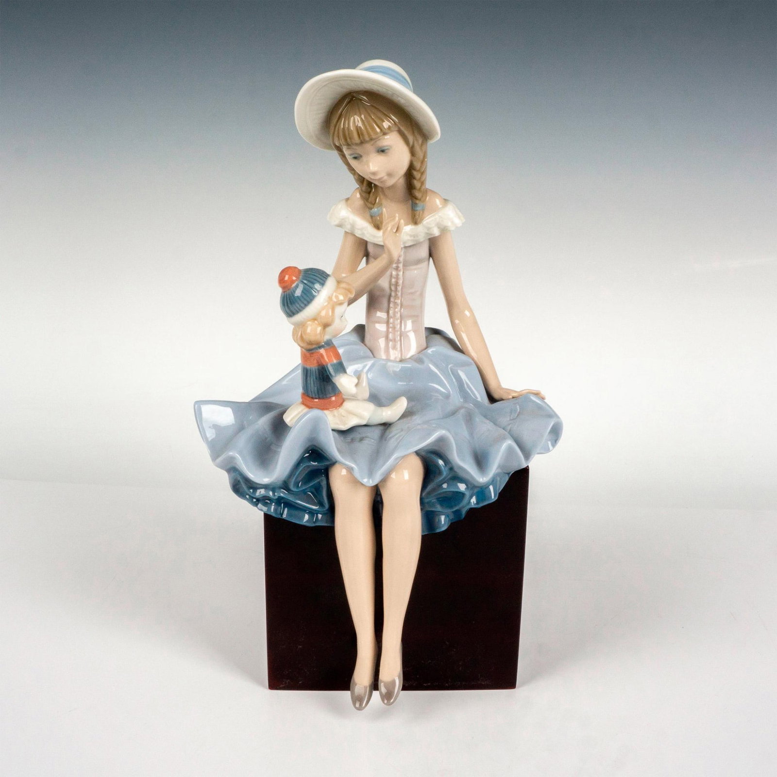 Suzy And Her Doll 1001378 - Lladro Porcelain Figurine: Glossy finish; Lladro backstamp. Artist: Salvador Debon Issued: 1978 - 1985 Dimensions: 11"H Manufacturer: Lladro Country of Origin: Spain