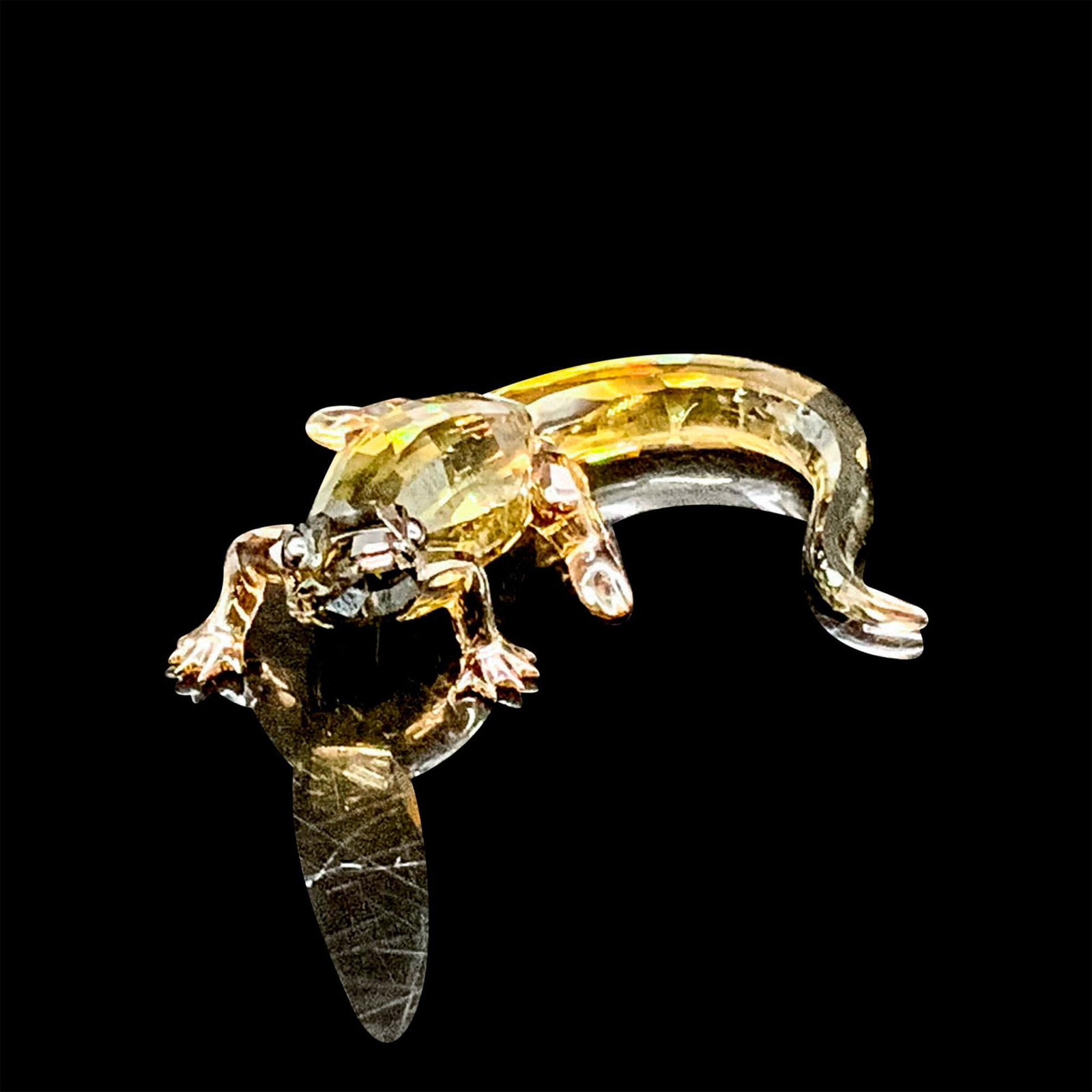 Swarovski Crystal Figurine, Baby Crocodile: A baby crocodile with head and body in Smokey Quartz with Jet eyes; 314 facets. Item comes with box measuring 3.25"dia. x 4.75"H. Issued: 2016 Dimensions: 2.75"L x 2"W x 0.75"H Manufacturer: Swarovski