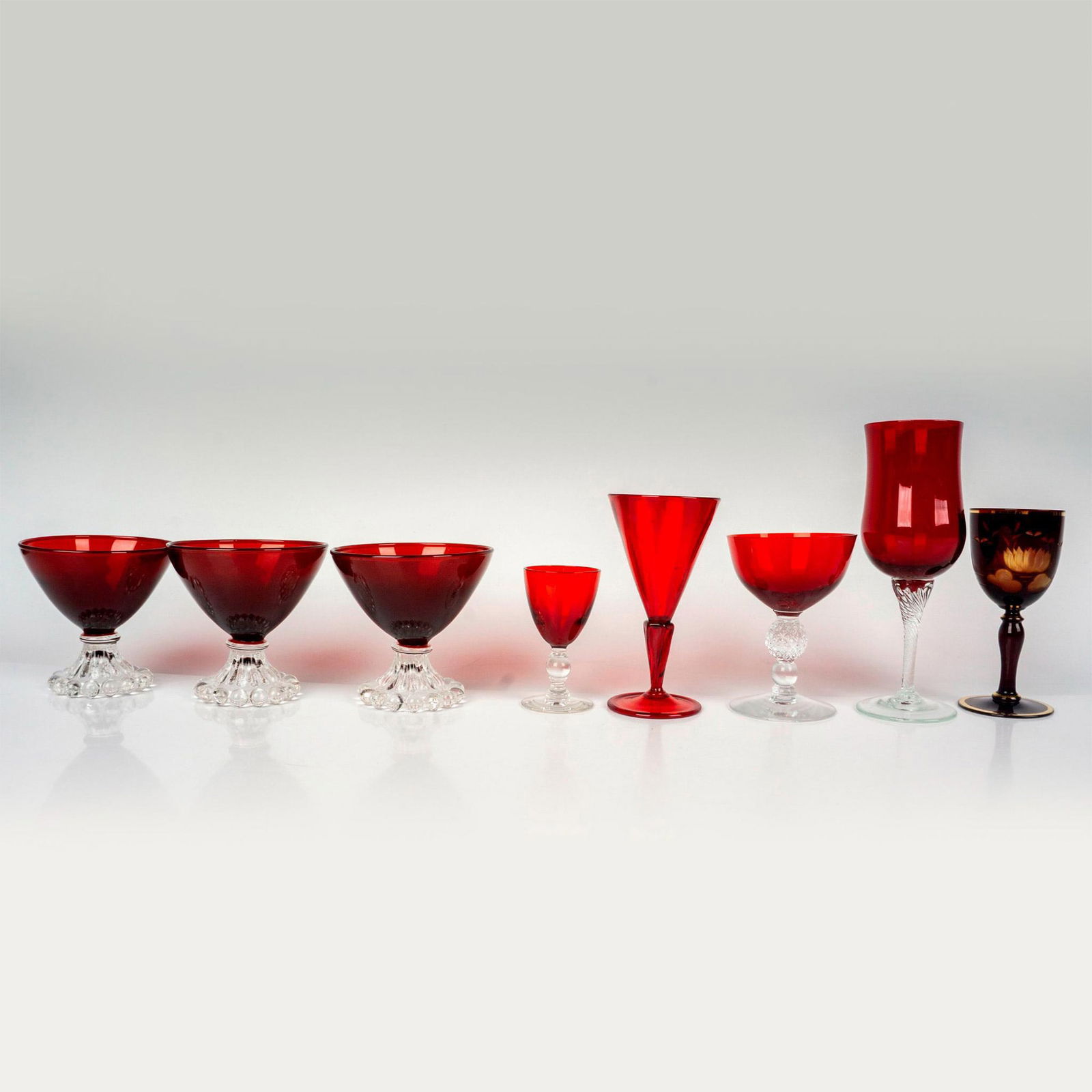 8pc Vintage Clear and Ruby Glass Stemware: Discover a delightful ensemble featuring cordial glasses, wine glasses, and dessert glasses. Each piece in this collection showcases exquisite deep ruby red glass, presented in a variety of complement