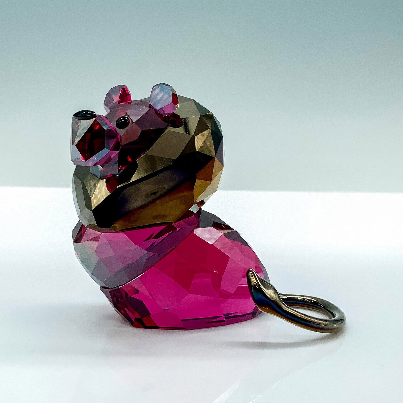 Swarovski Crystal Lovelots Figurine, Leo Lion 1079591: A magenta crystal lion with gold colored plating used for his mane and tail and black crystals for the eyes. Swarovski backstamp. This item has its original box. Dimensions of the original box: 5.5"L 
