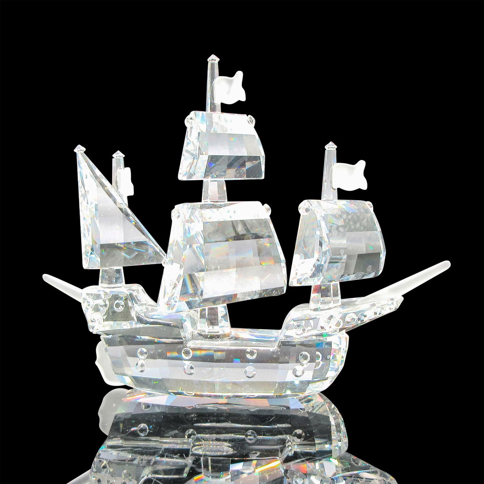 Swarovski Silver Crystal Figurine, Santa Maria: Part of the When We Were Young series. Clear faceted ship and sails. Flags, bow and stern are frosted crystal. Swarovski backstamp. This item has its original box: 5"H x 6"dia. Artist: Gabriele Stamey
