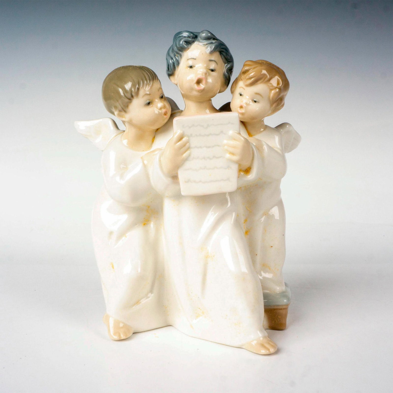 Group Of Angels 1004542 - Lladro Porcelain Figurine: Glossy finish; Lladro backstamp. Includes original box. Box measures: 9.5"L x 9"W x 6.5"H. Artist: Fulgencio Garcia Issued: 1969 - 2004 Dimensions: 7"H x 4.75"W Manufacturer: Lladro Country of Origin: